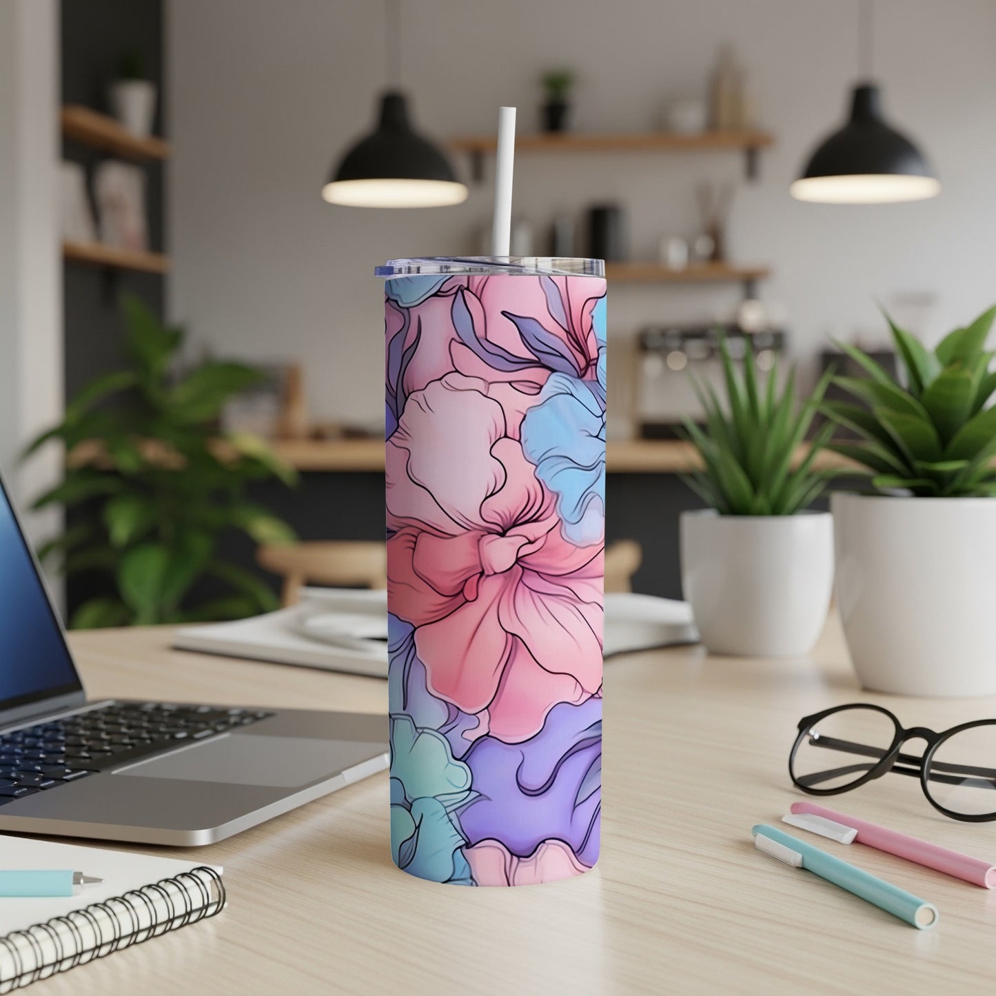 Floral patterned tumbler with a straw on a desk.