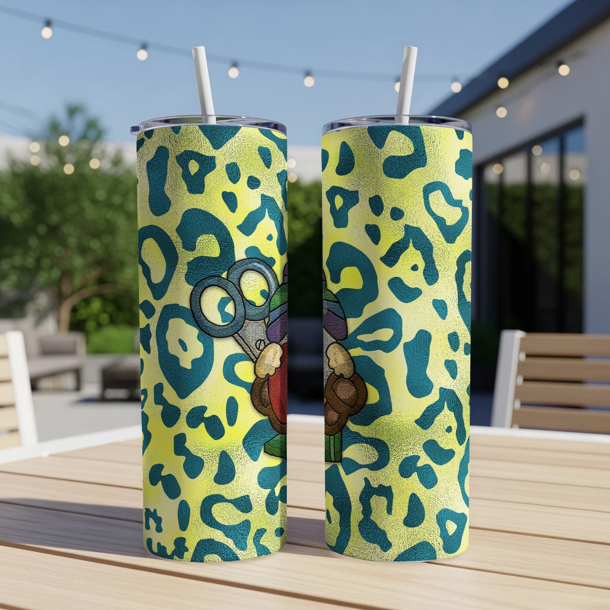 Two yellow tumblers with leopard print and scissors graphic sit on a table.