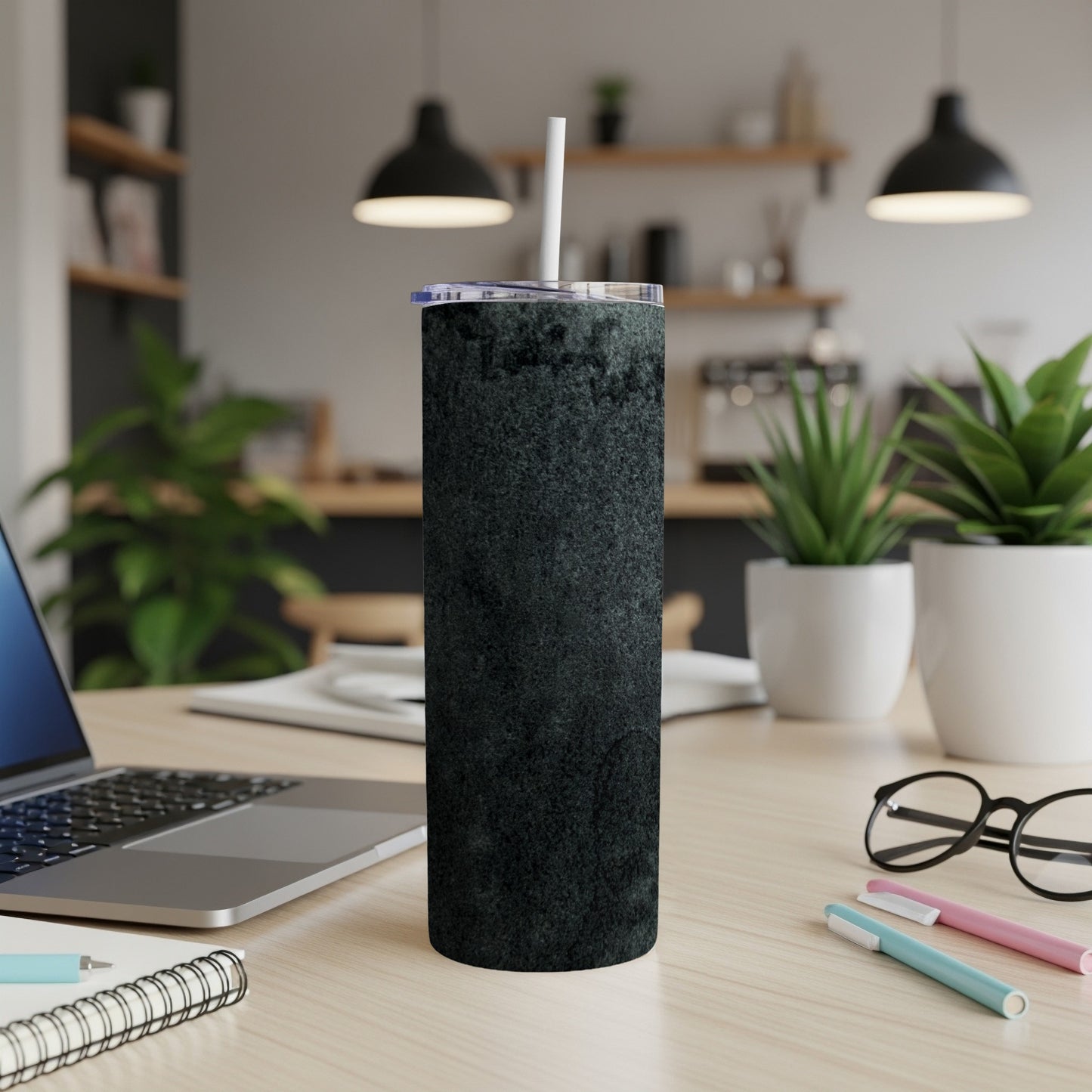 Dark textured tumbler with a white straw on a desk.