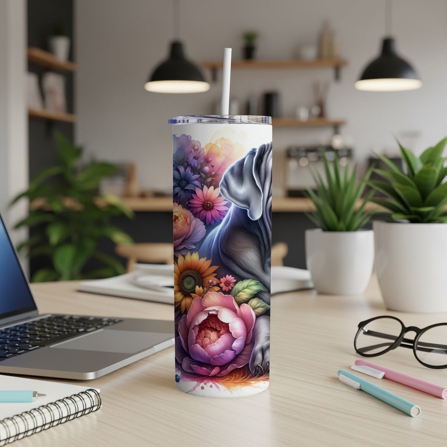 Elephant and floral art on a skinny tumbler with a straw.