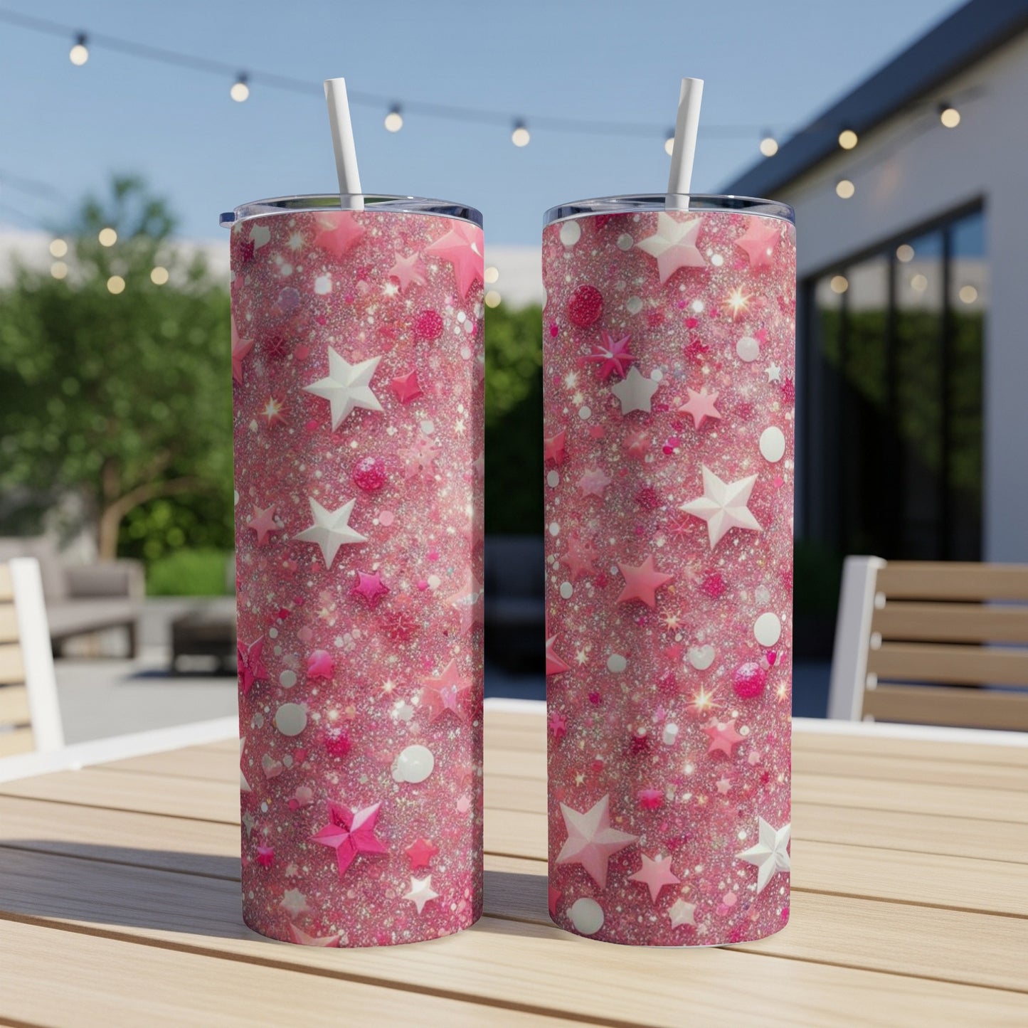 Two pink glitter tumblers with star and heart designs on a table.