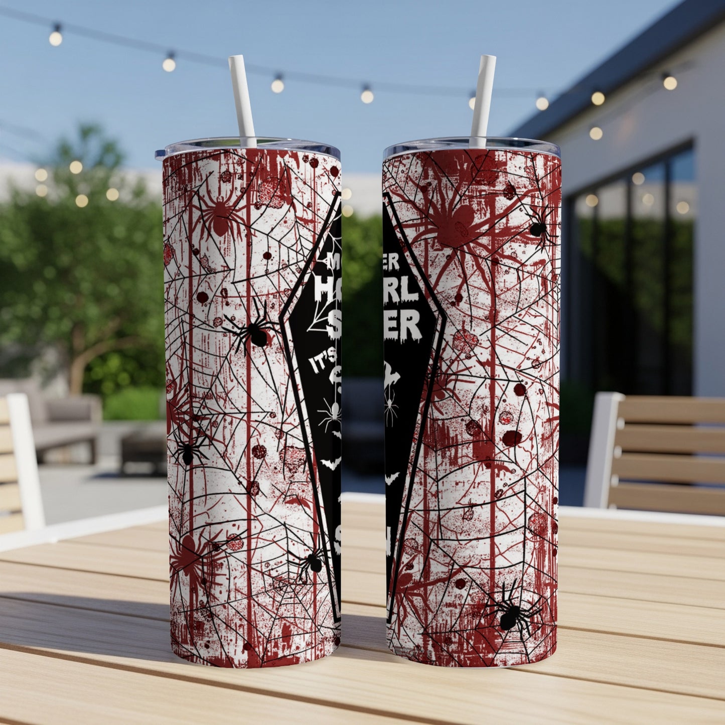 Two Halloween-themed tumblers with spiders and blood splatters, on a wooden table.