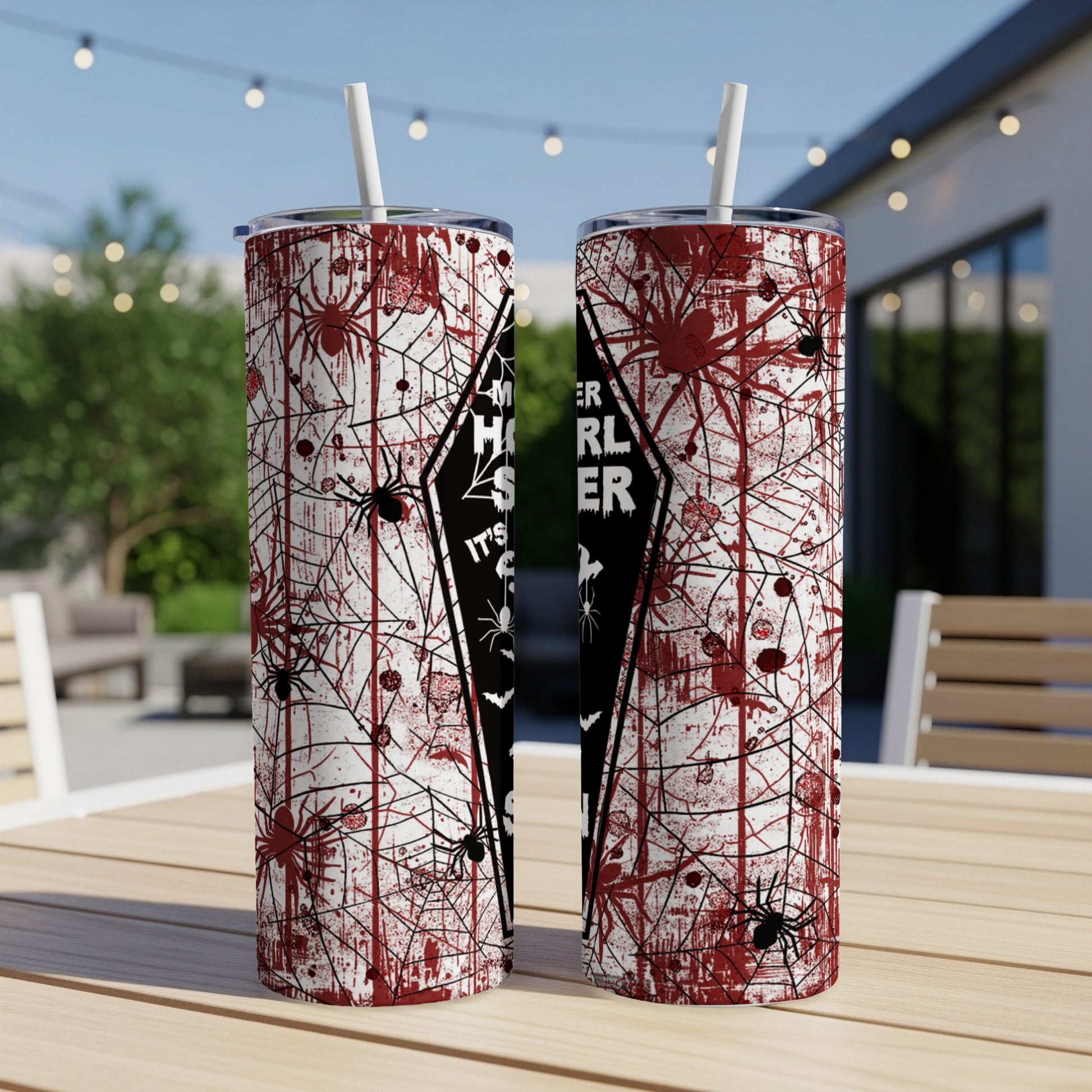 Two Halloween-themed tumblers with spiders and blood splatters, on a wooden table.