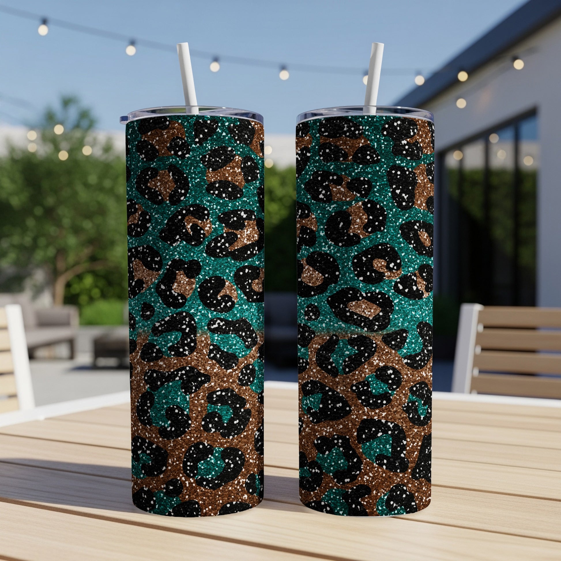 Two leopard print tumblers with teal and brown glitter on a table.