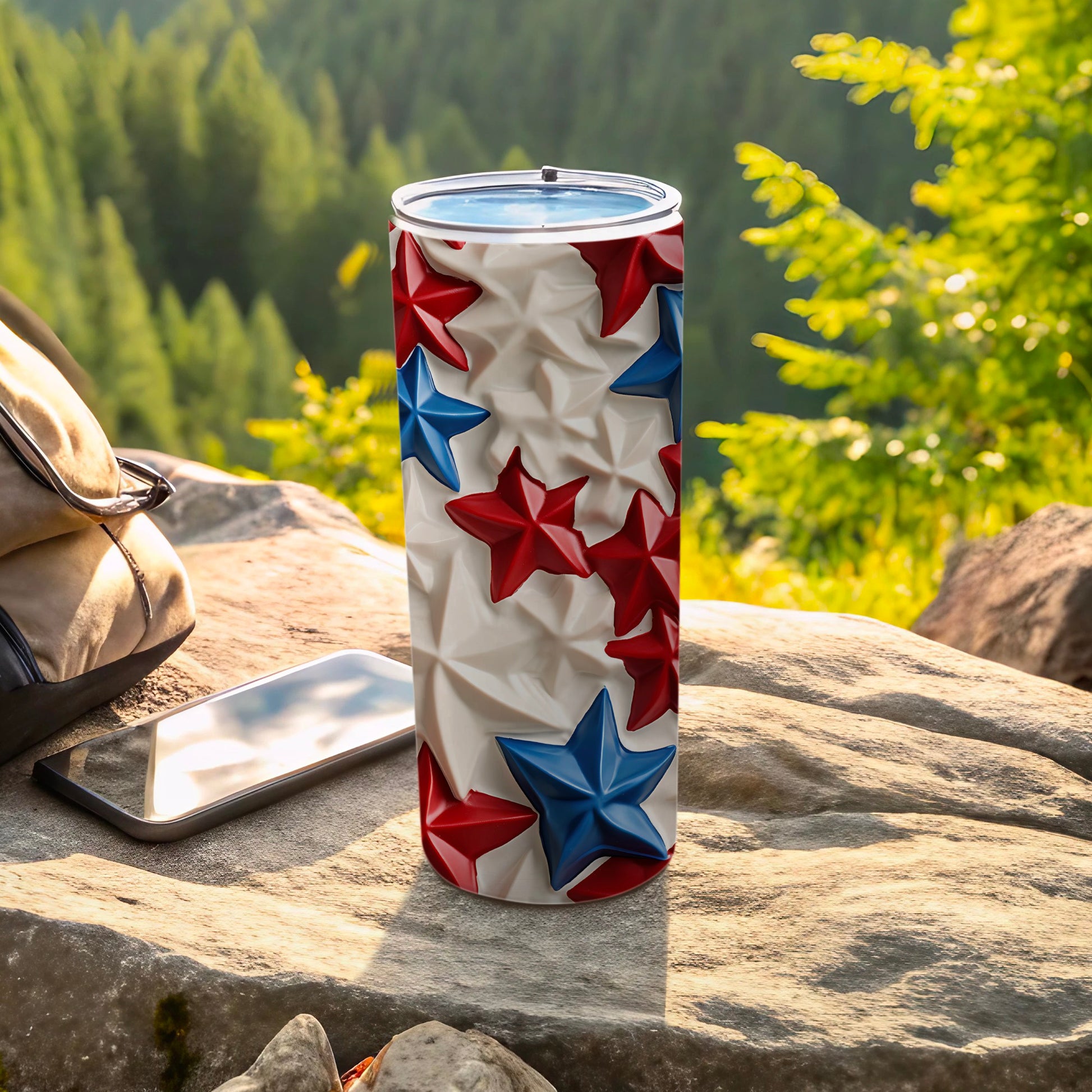 Red and blue stars on a white textured tumbler, resting on rocks outdoors.