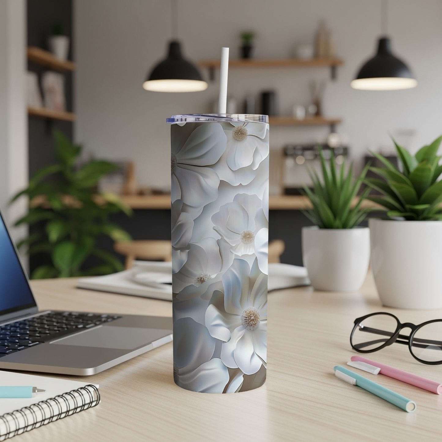 White floral pattern tumbler with straw on a desk.