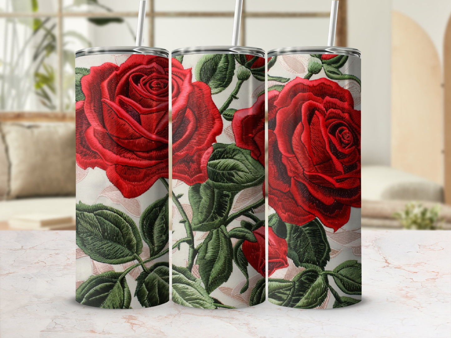 Three tumblers with a red rose floral design and straws.