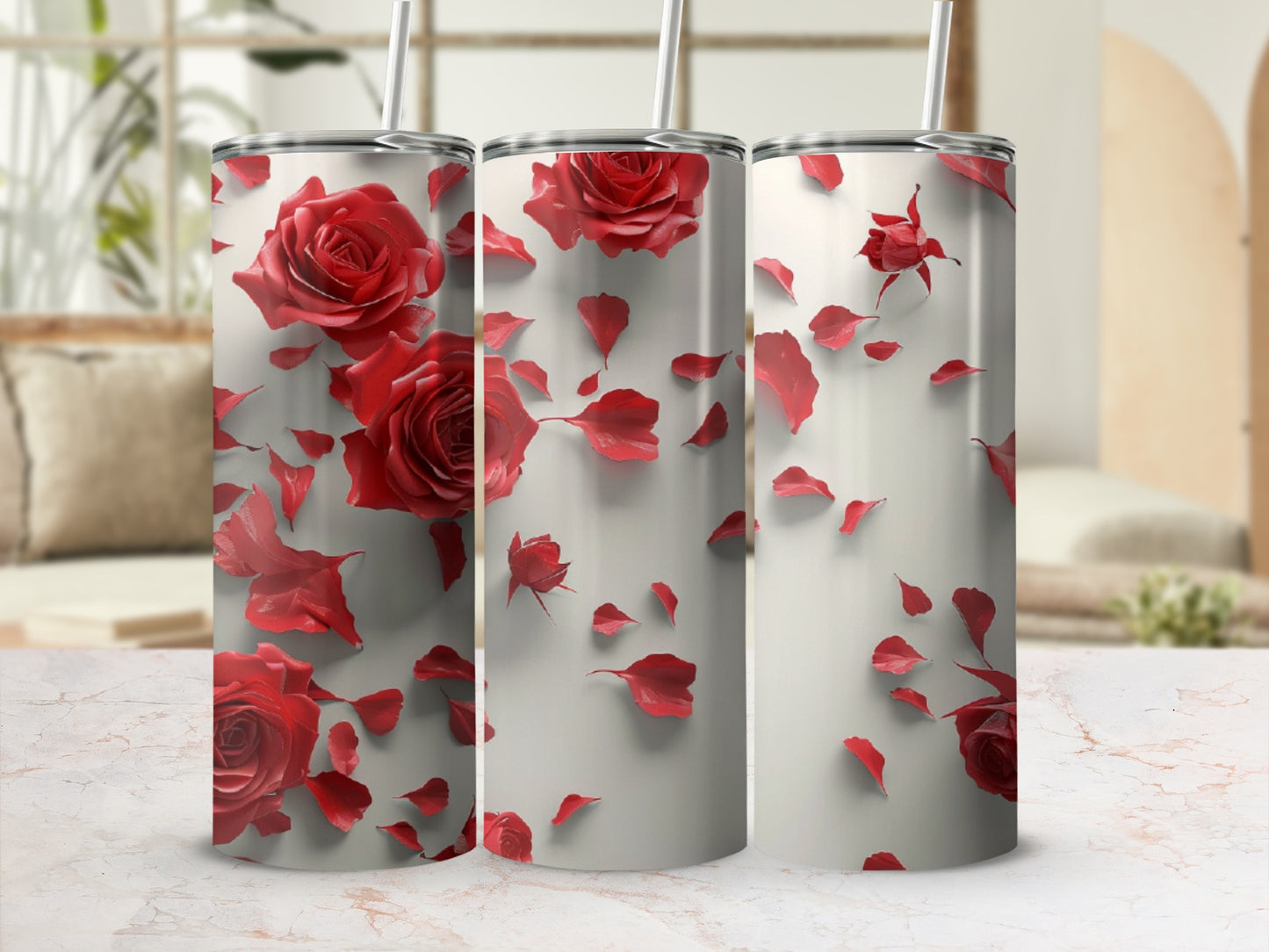 Three tall tumblers decorated with red roses and petals against a blurred background.