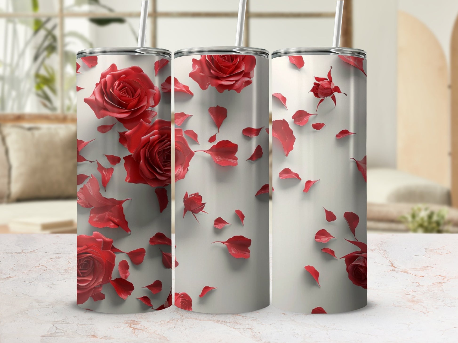 Three tall tumblers decorated with red roses and petals against a blurred background.