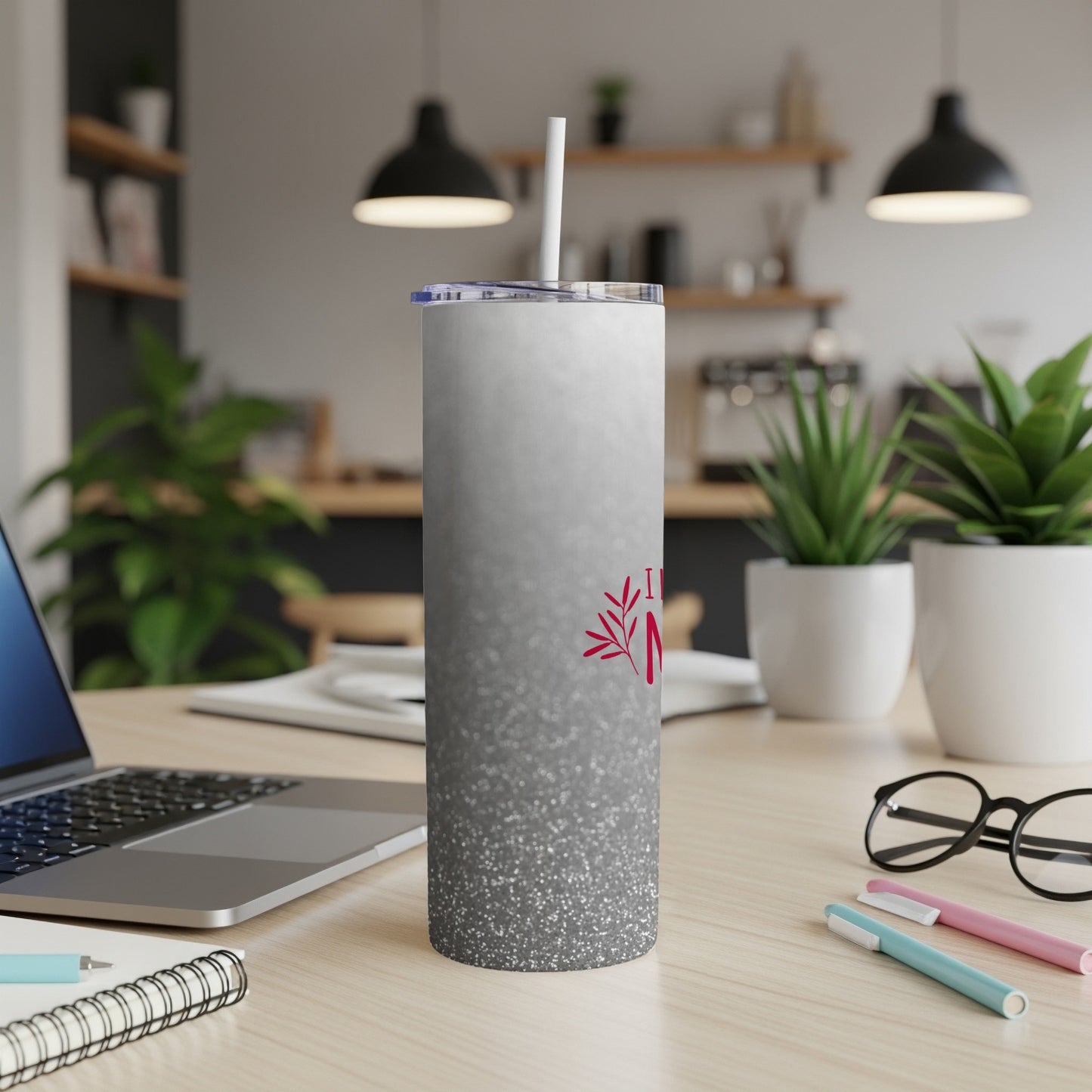 Glittery white tumbler with red "Mom" text and straw on a desk.