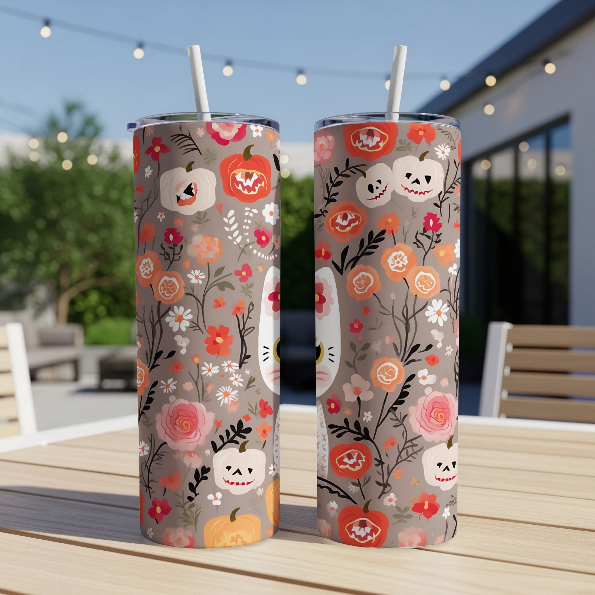 Two tumblers with a Halloween floral pattern featuring pumpkins and skulls.