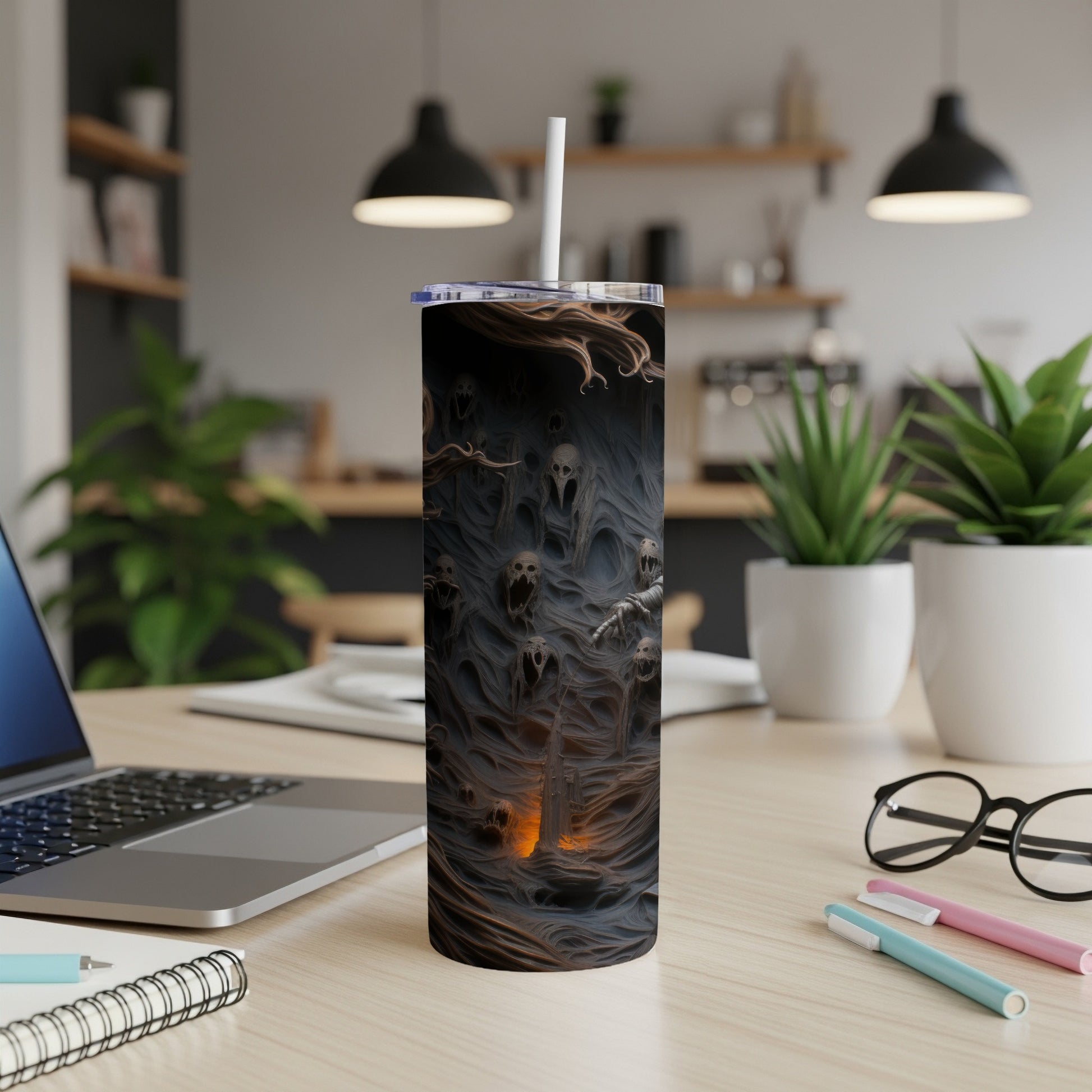 Tumbler with a dark, haunting design of screaming skulls and tendrils.