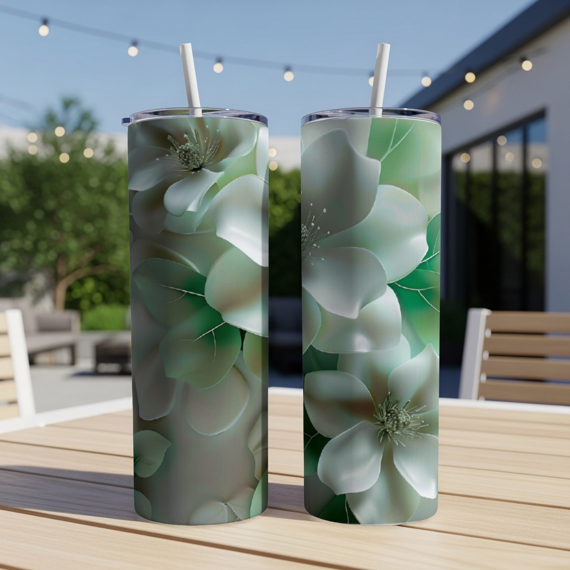 Two tall, slim tumblers with a light green floral pattern on a wooden table.