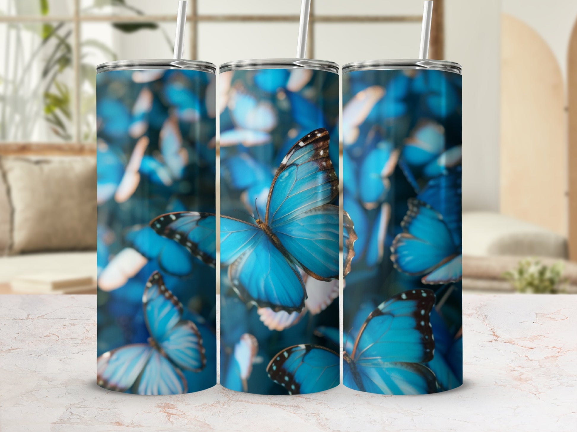 Three tumblers with a close-up blue butterfly pattern, displayed on a marbled surface.
