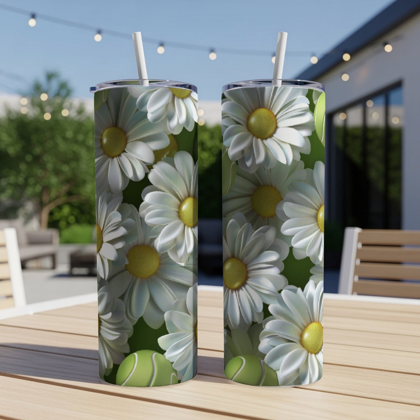 Two tumblers with a daisy floral pattern sit on a table outdoors.