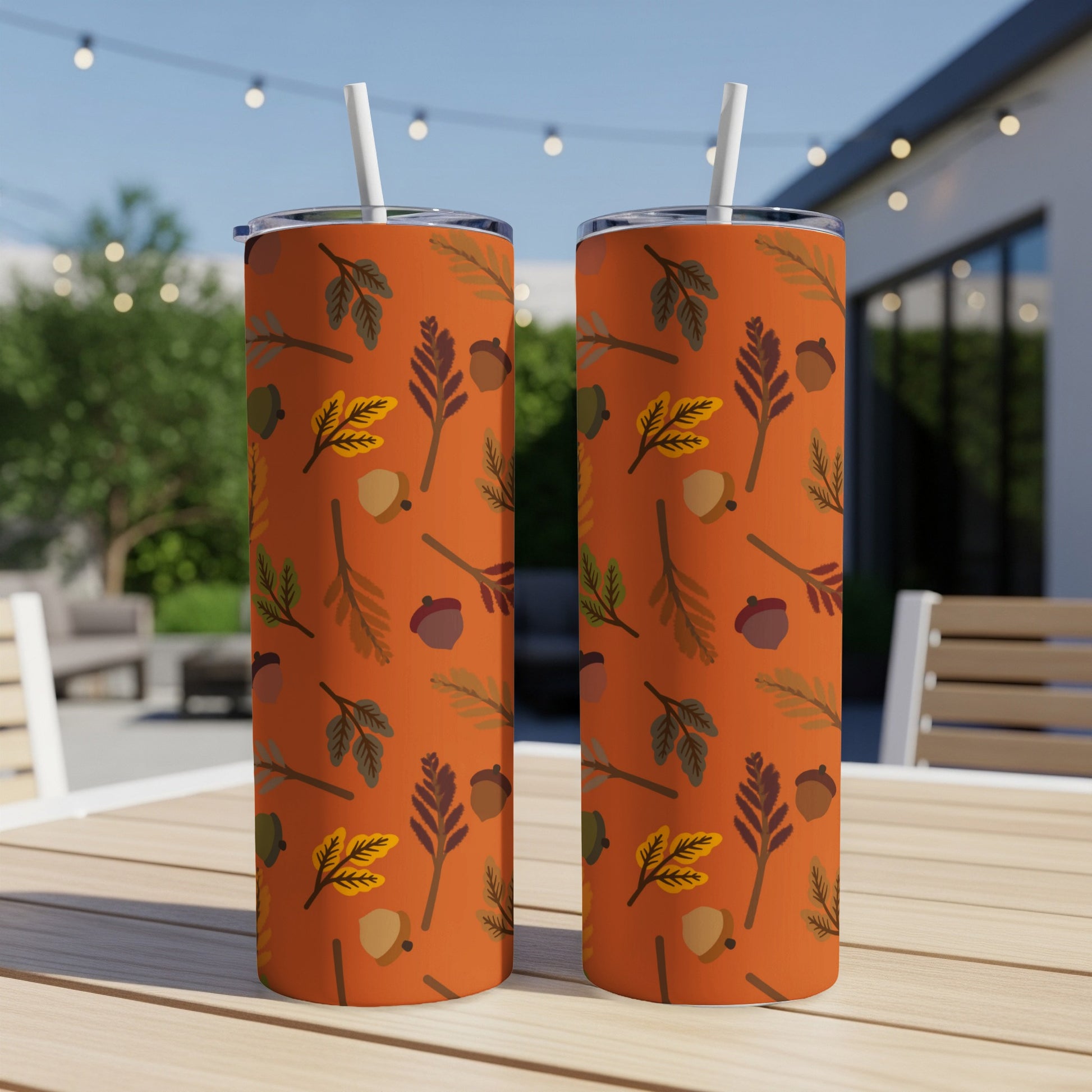Two tumblers with an orange background and fall leaf and acorn pattern.