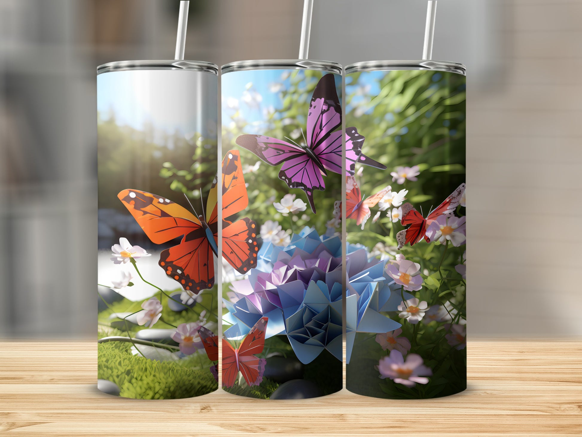 Three tumblers with vibrant butterfly and floral designs on a wooden surface.