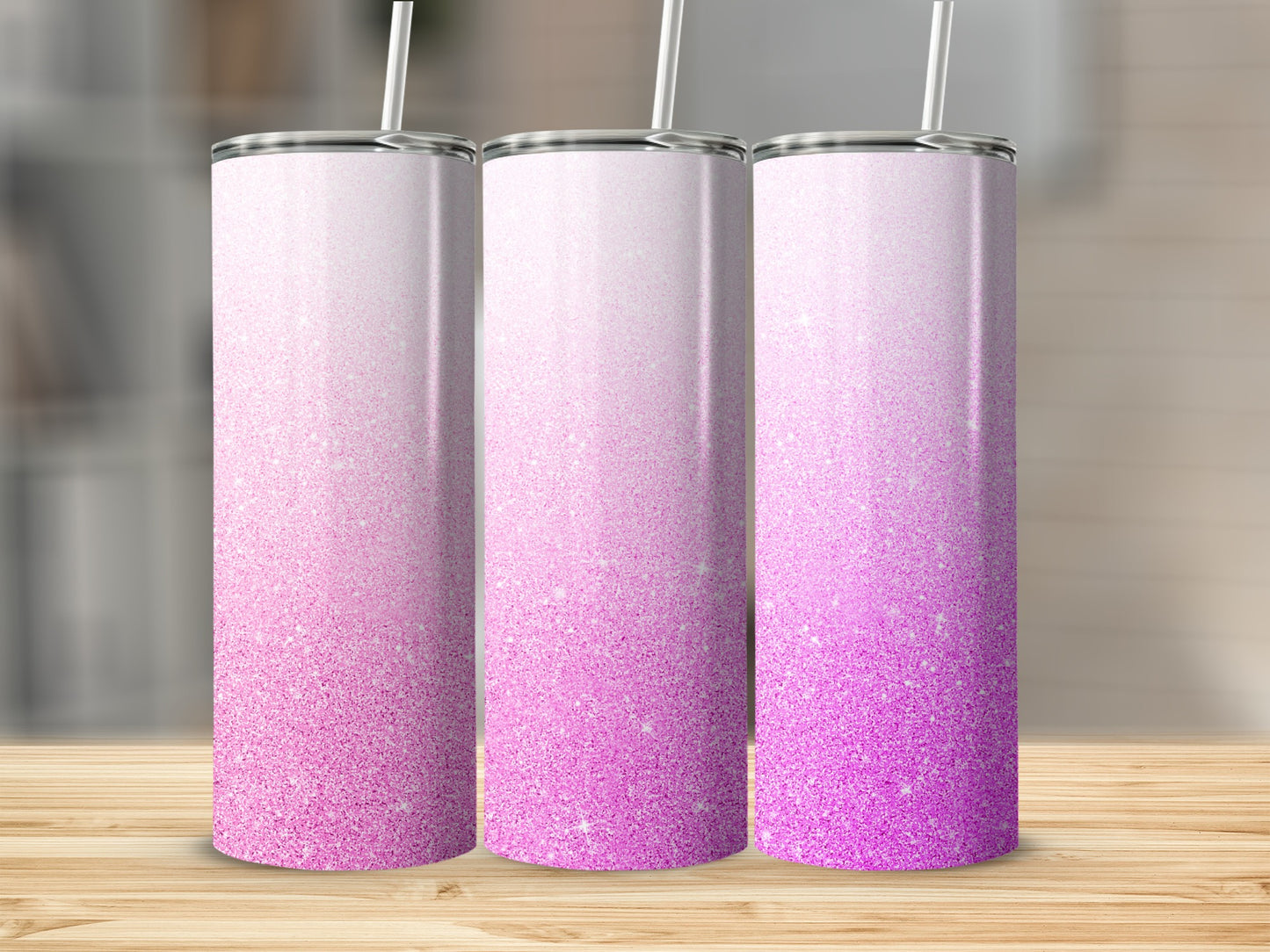 Three tall tumblers with a pink glitter ombre design and white straws.