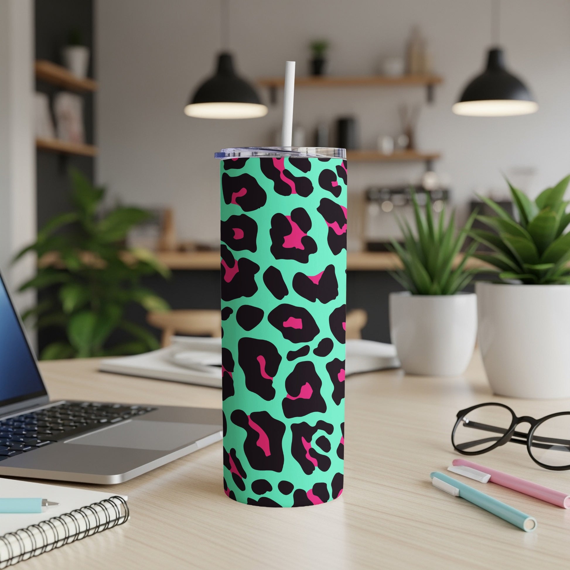 Tall tumbler with teal, black, and pink leopard print and a white straw.