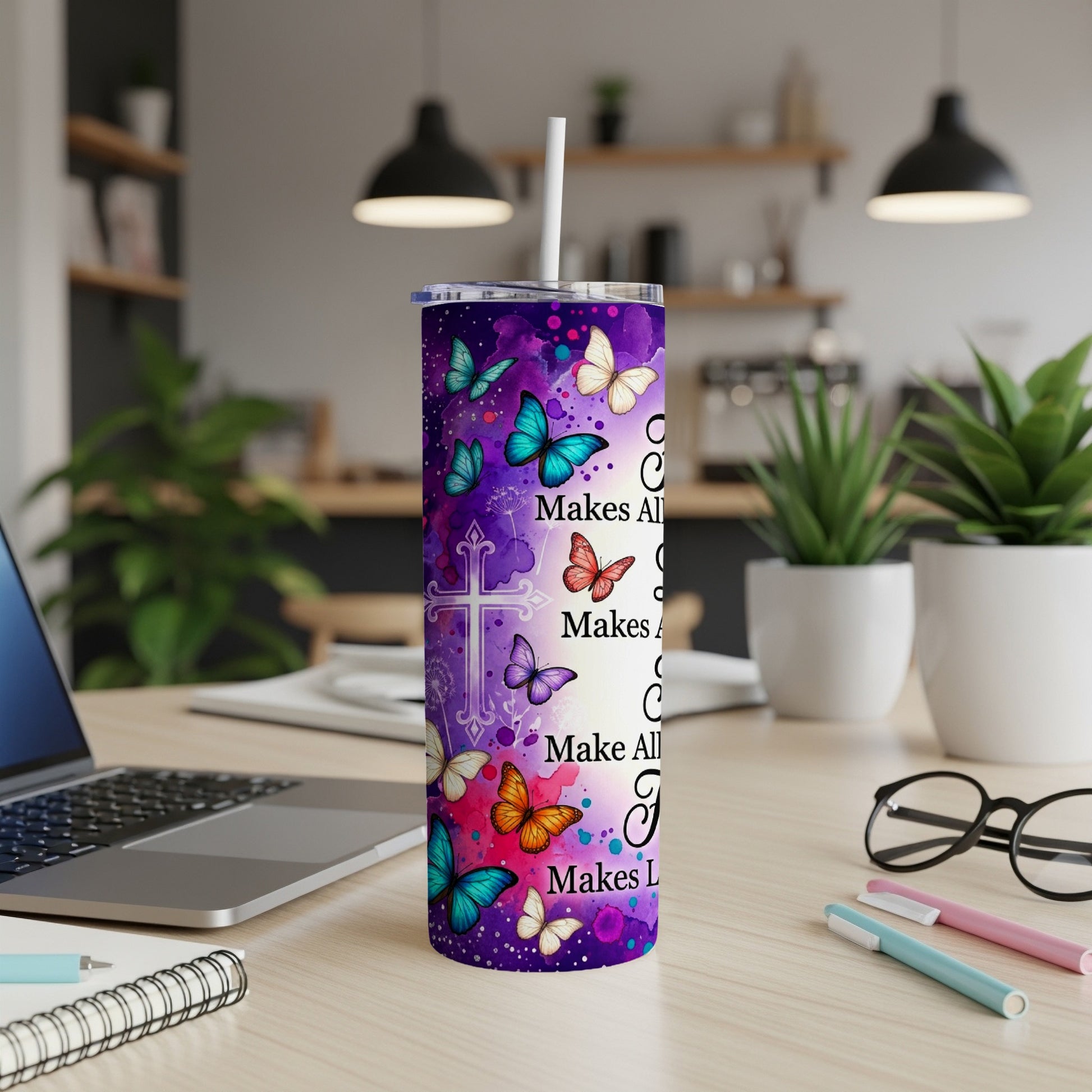 Purple tumbler with butterflies and Christian cross, reads "He Makes All Things Beautiful".