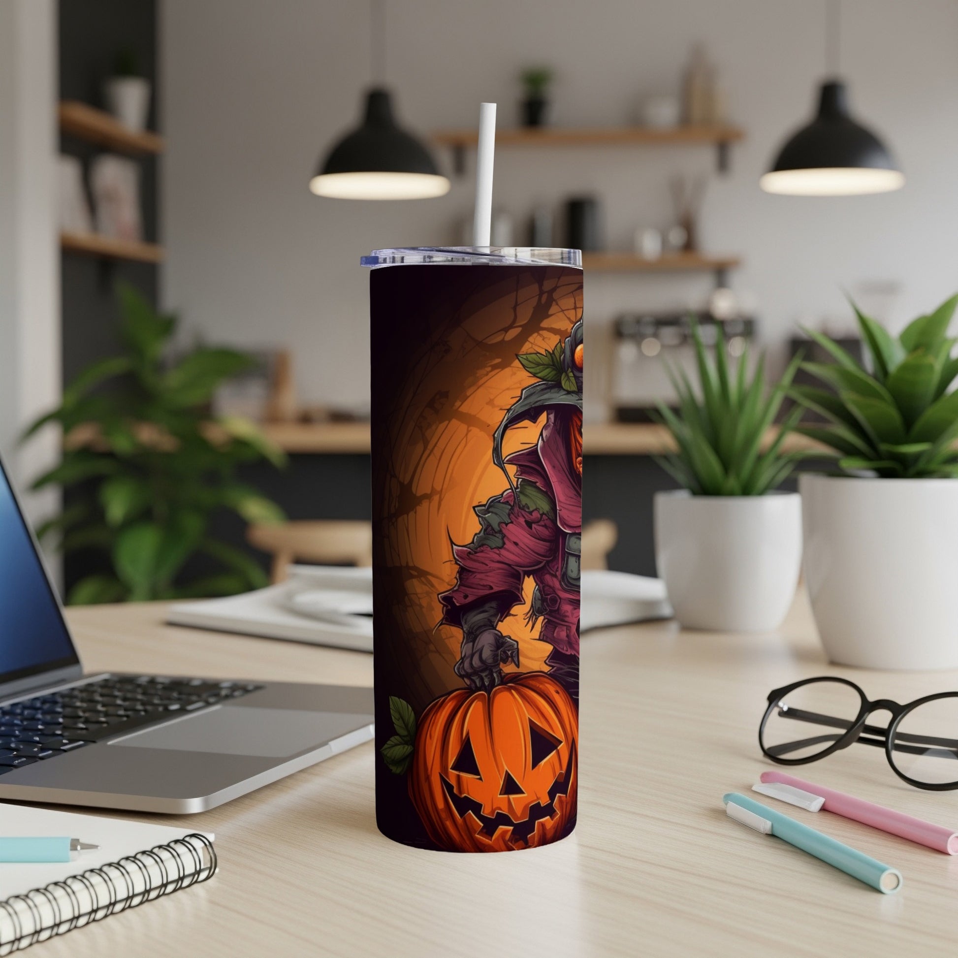 Tumbler with a Halloween scarecrow holding a Jack-o'-lantern on a wooden desk.