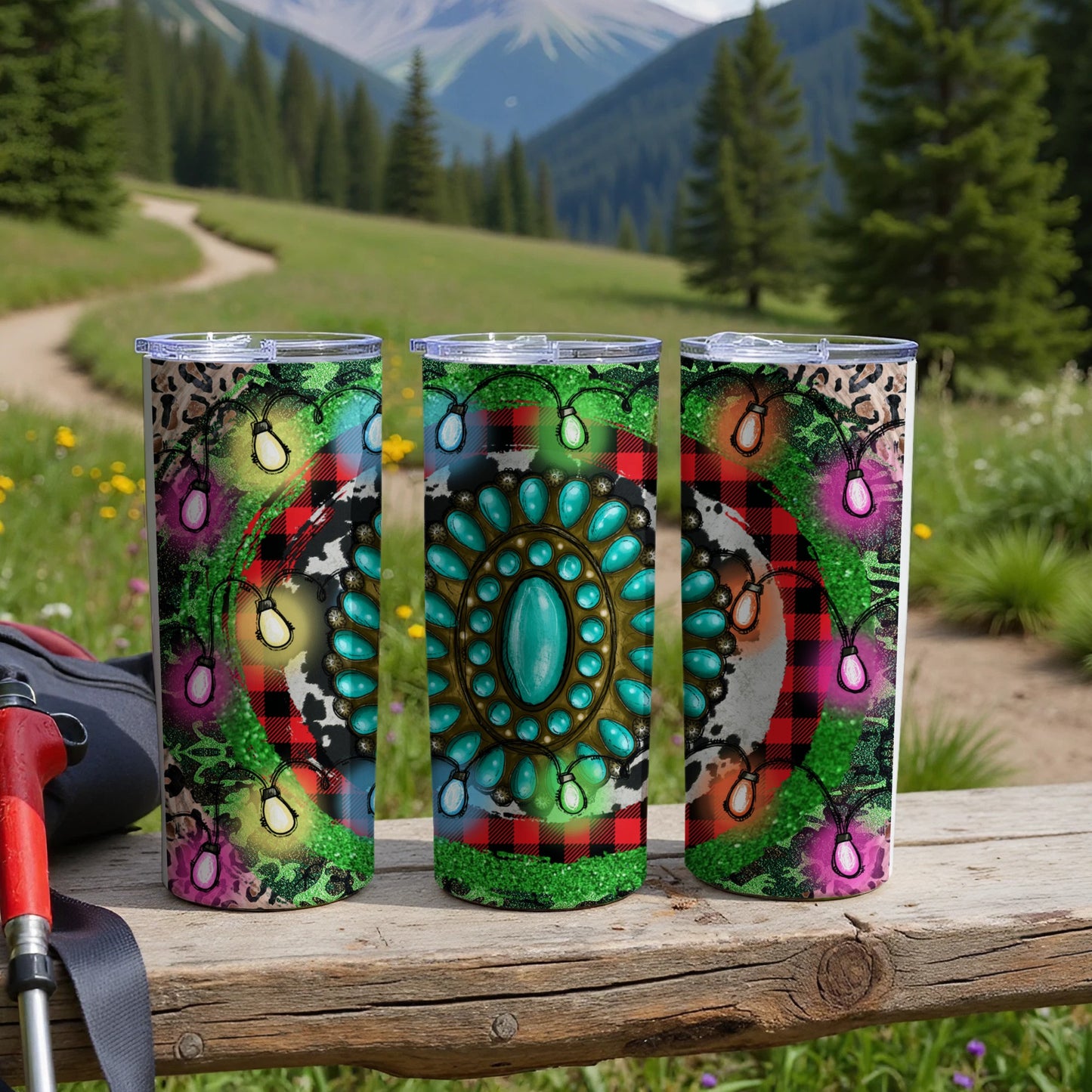 Three tumblers with teal gems, plaid, and festive lights on a wooden surface.