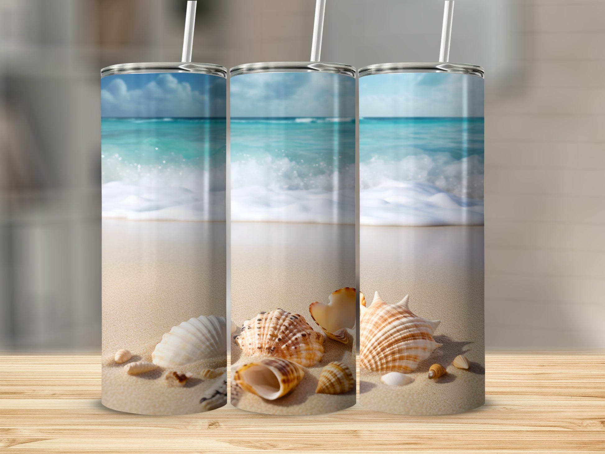 Three tumblers with a beach and seashell design on a wooden surface.