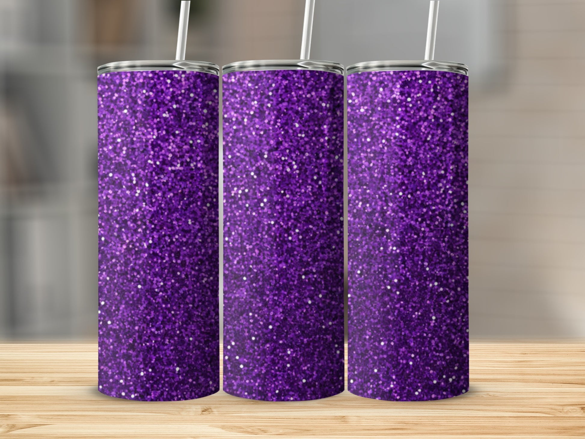 Three purple glitter tumblers with straws stand on a wooden surface.