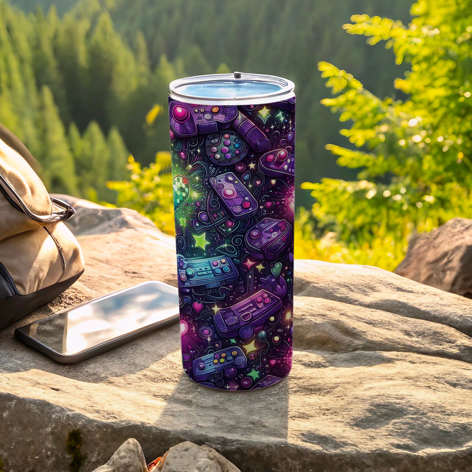 Purple tumbler with colorful video game controllers and icons on a rocky surface.