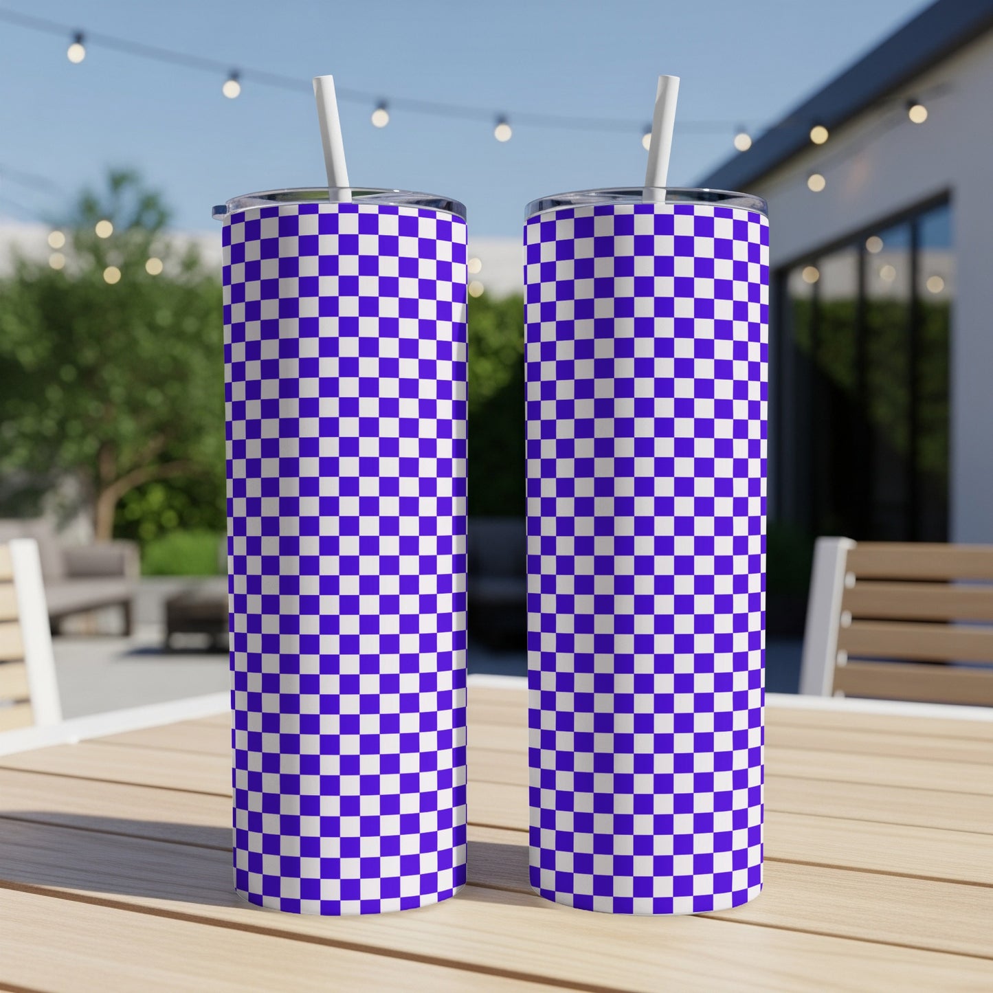 Two purple and white checkered tumblers with straws on a wooden table.