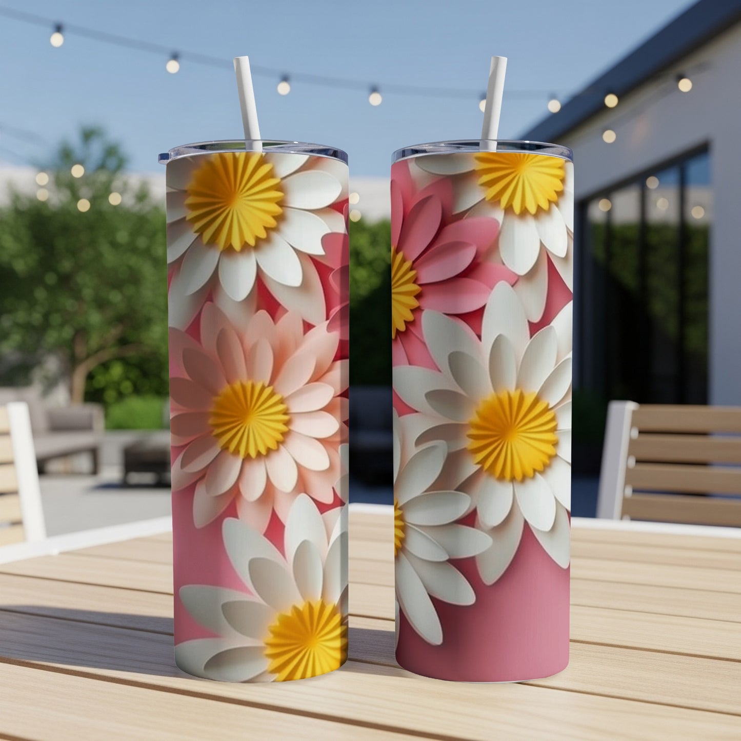 Two pink and white floral tumblers with straws on a table.