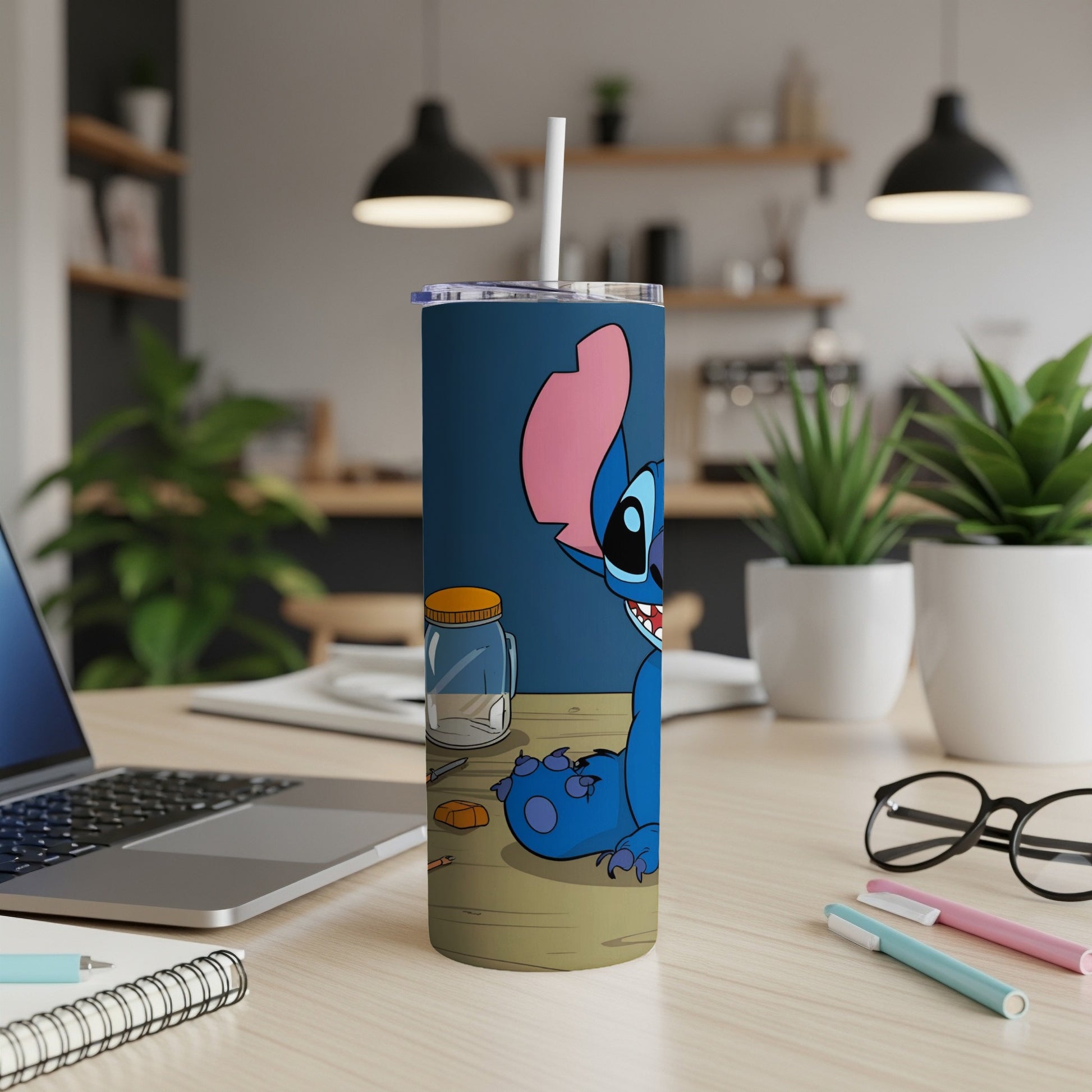 Blue Stitch character with straw, on a blue tumbler on a desk.