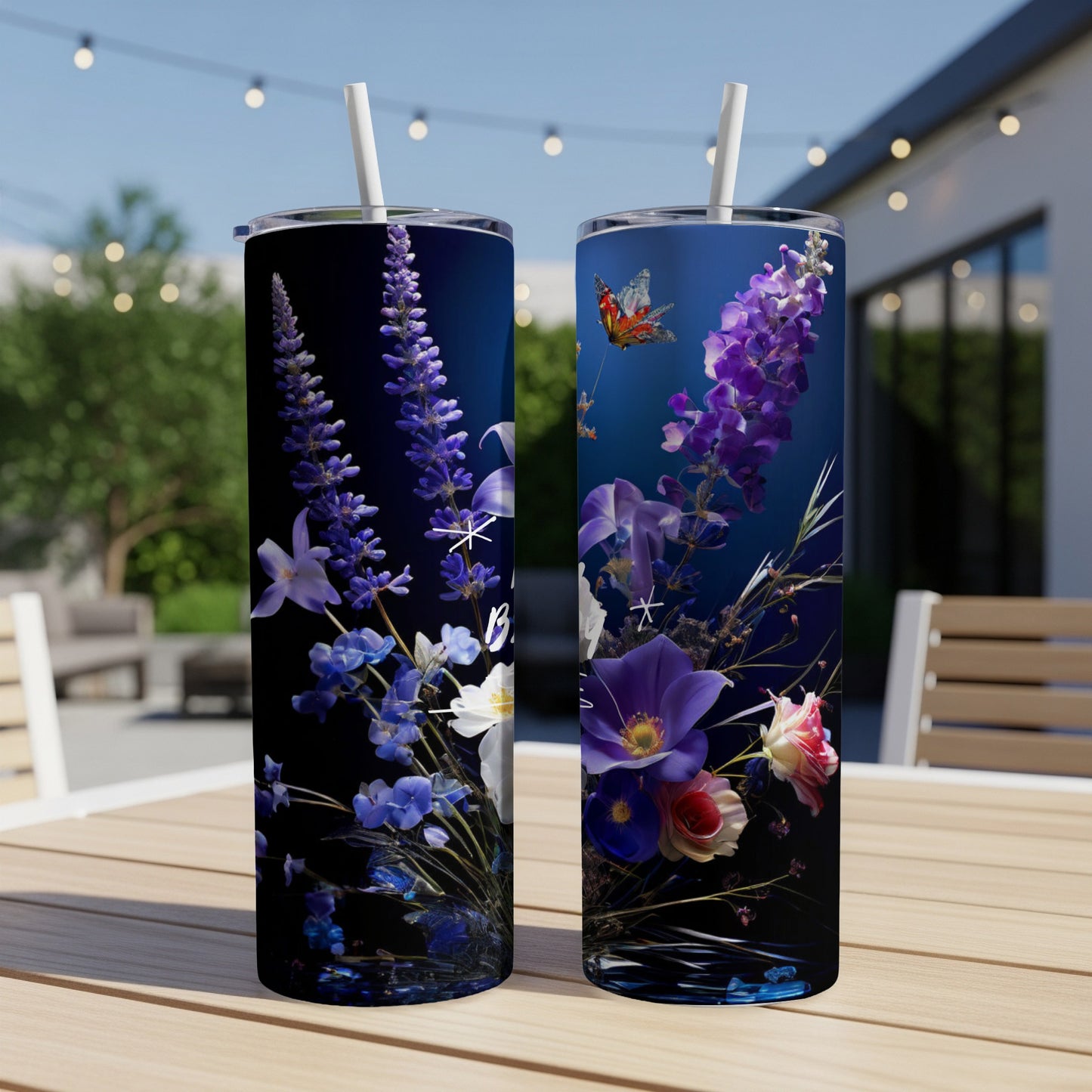 Two dark blue tumblers with floral and butterfly designs, resting on a wooden table.