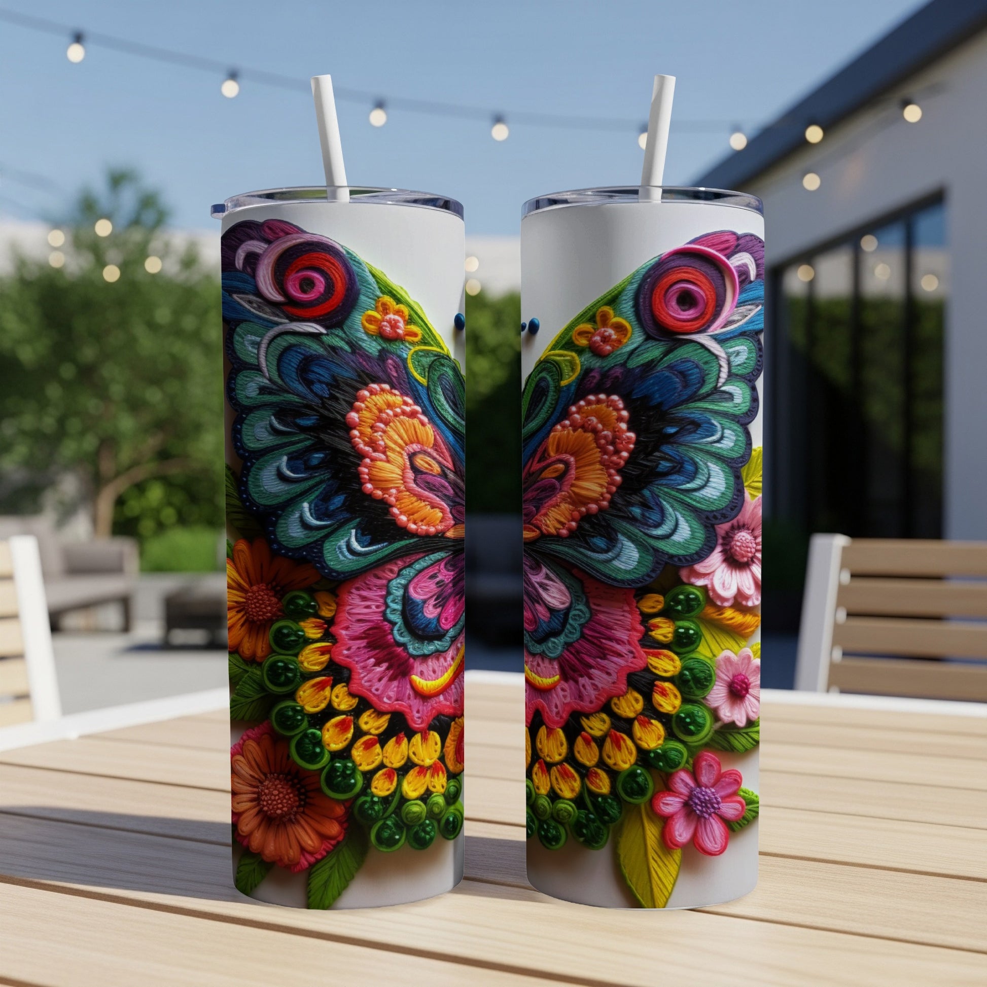 Two colorful butterfly-themed tumblers with straws on a wooden table.