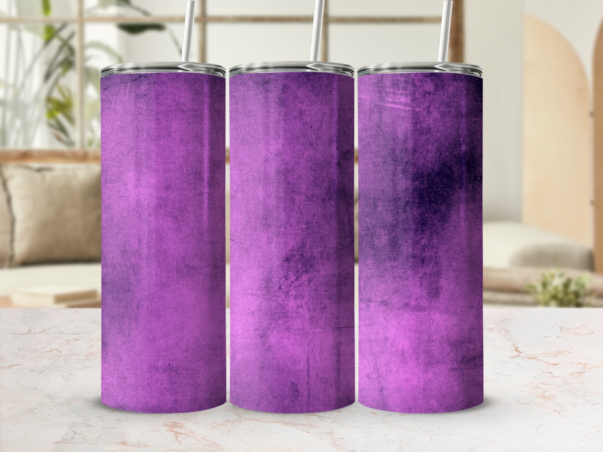 Three purple gradient tumblers with straws on a marble surface indoors.