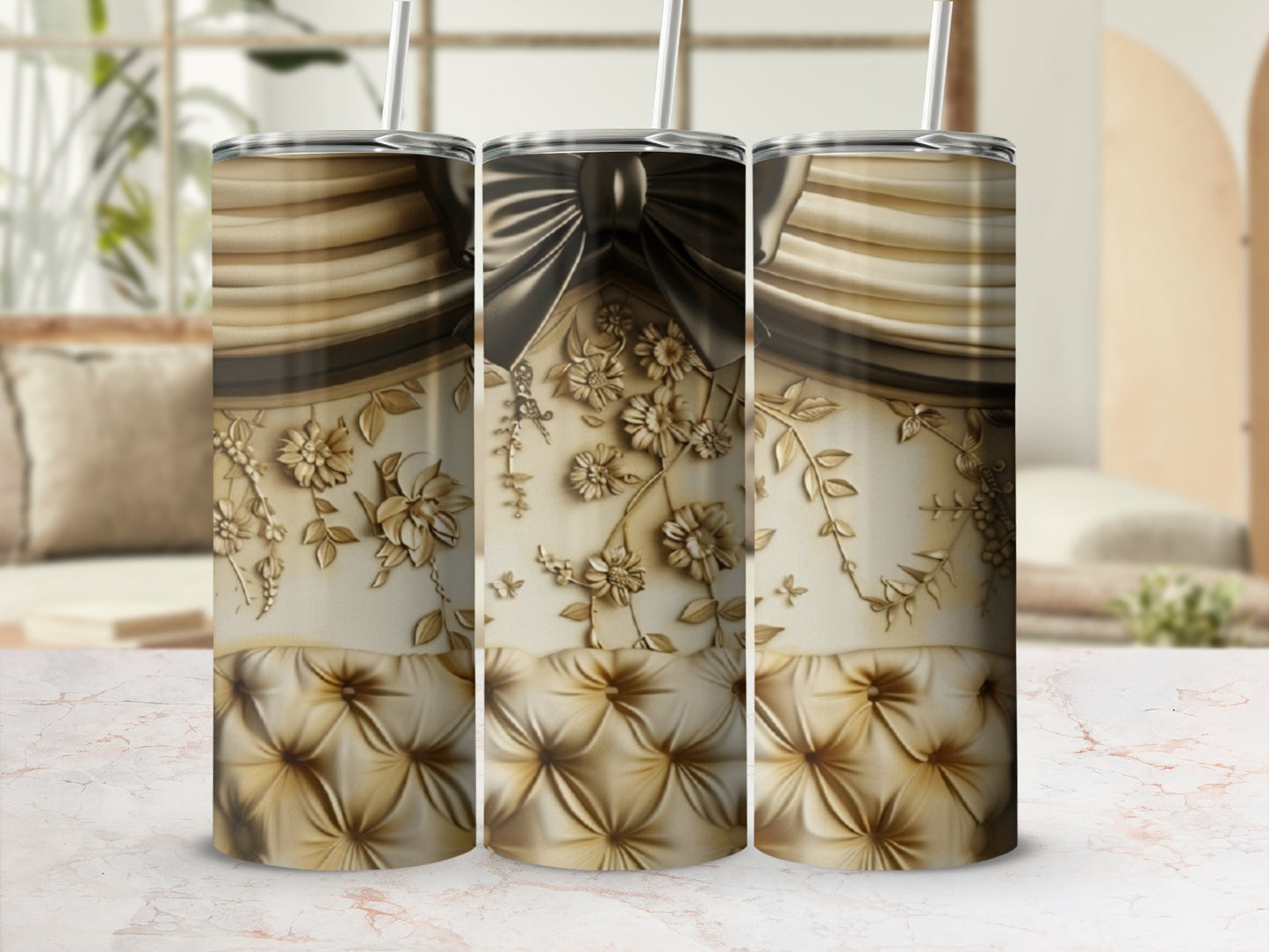 Gold floral embossed tumbler with a bow detail, displayed on a marble surface.