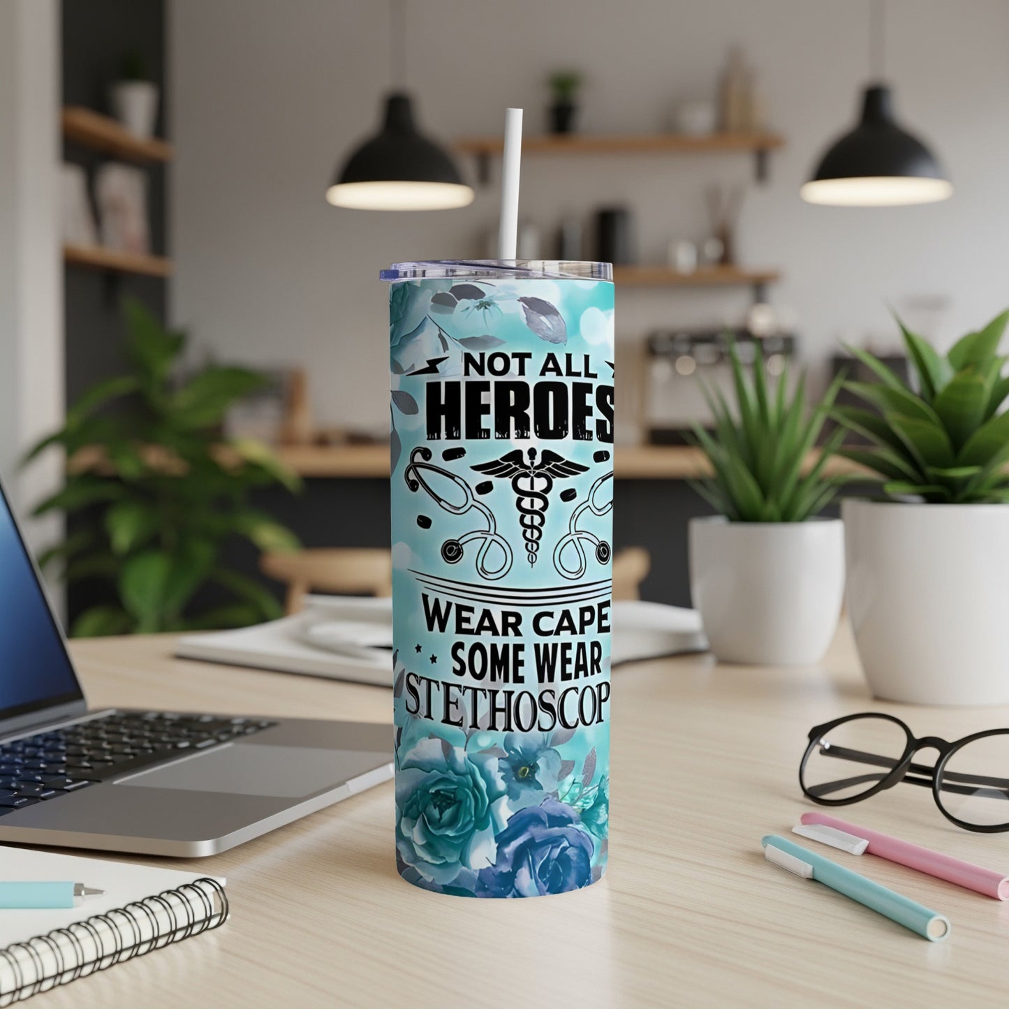 Blue floral tumbler with "Not all heroes wear capes some wear stethoscope" text.