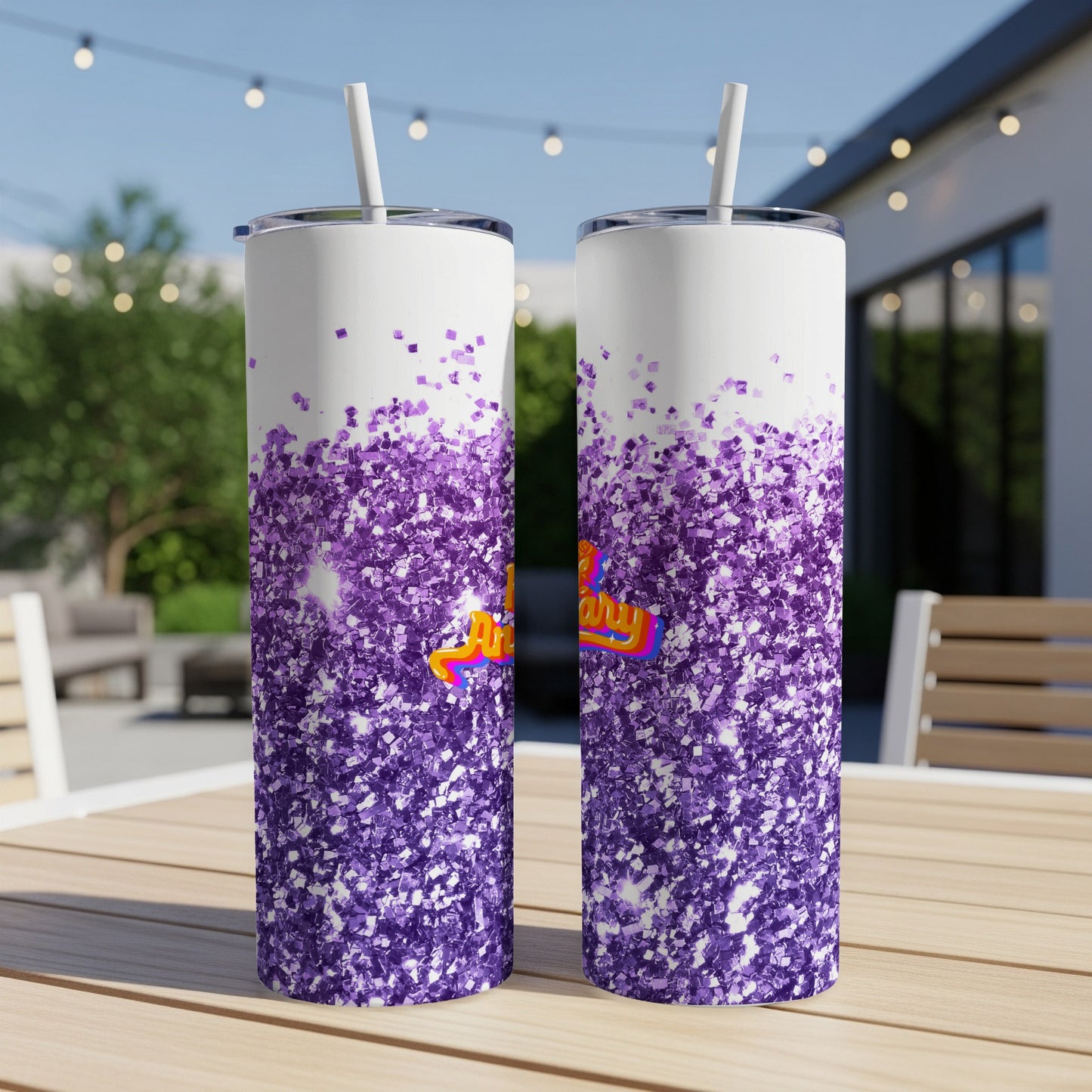 Two tumblers with purple glitter and "Happy Birthday" text on a table outdoors.