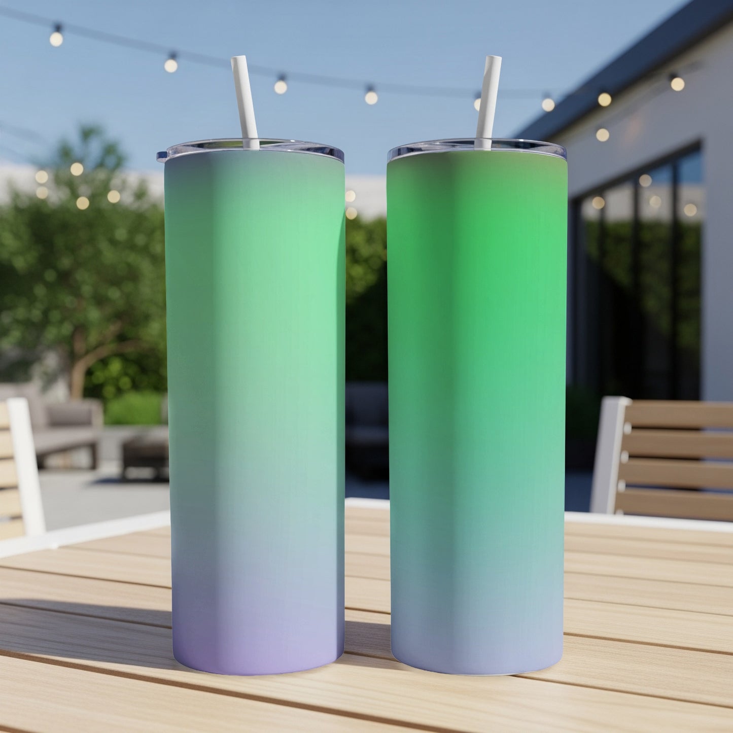 Two tumblers with green to purple gradient and white straws sit on a wooden table.