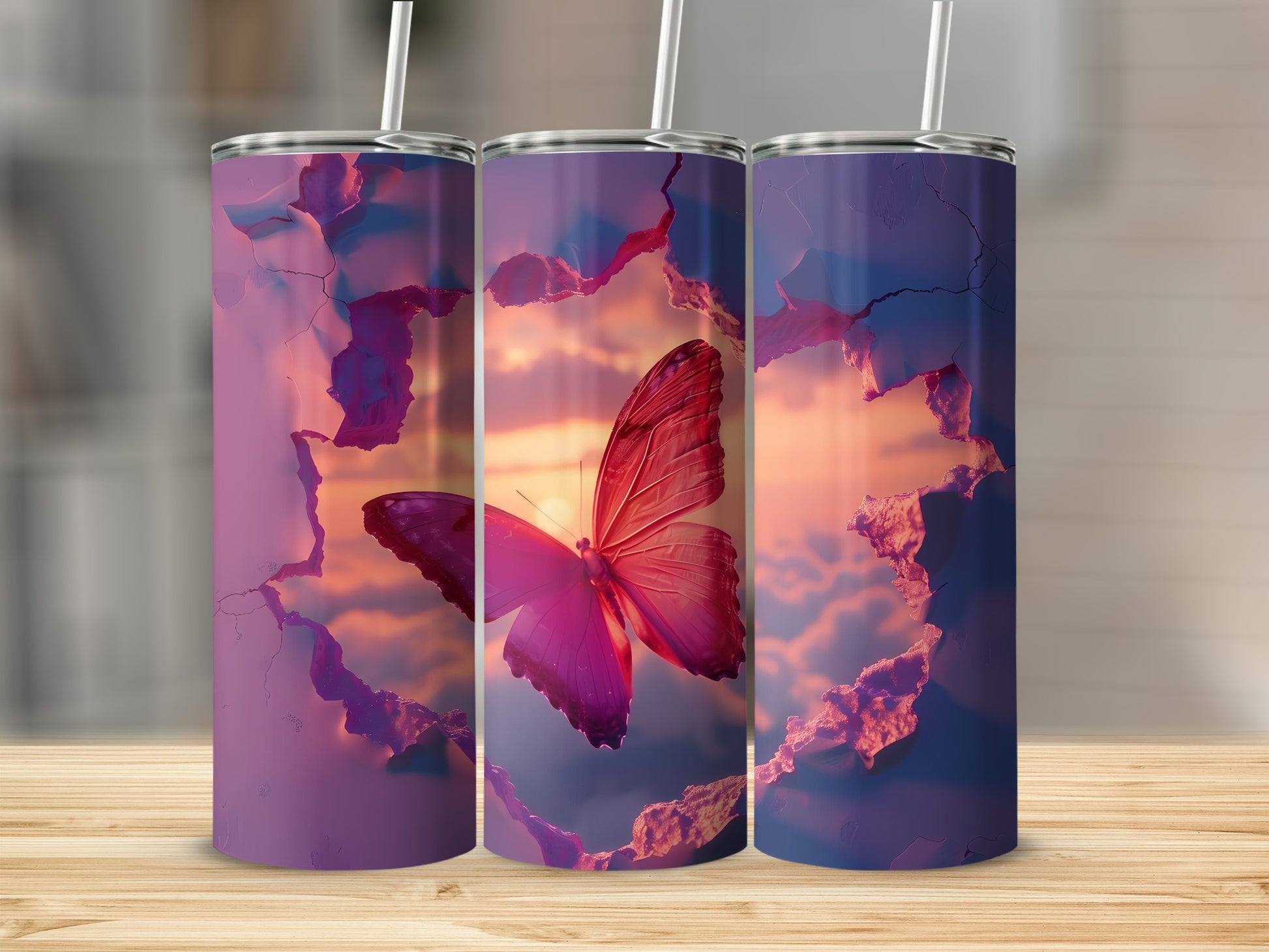 Three tumblers with a butterfly and sunset design on a wooden surface.