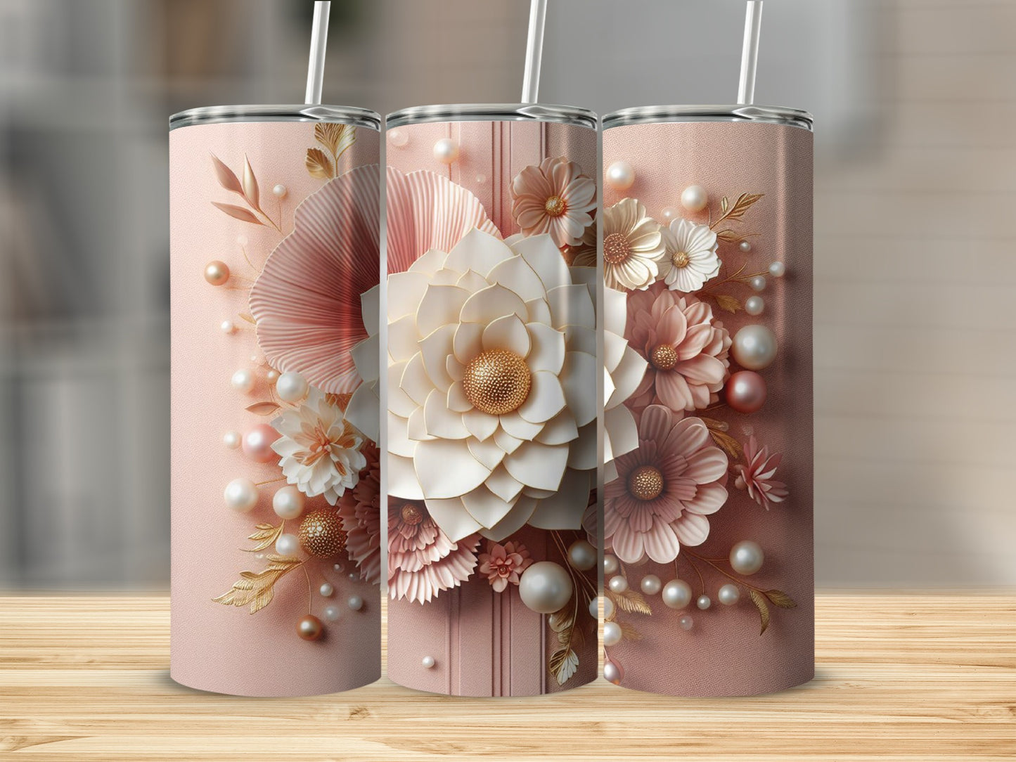 Three pink tumblers with floral and pearl designs on a wooden surface.