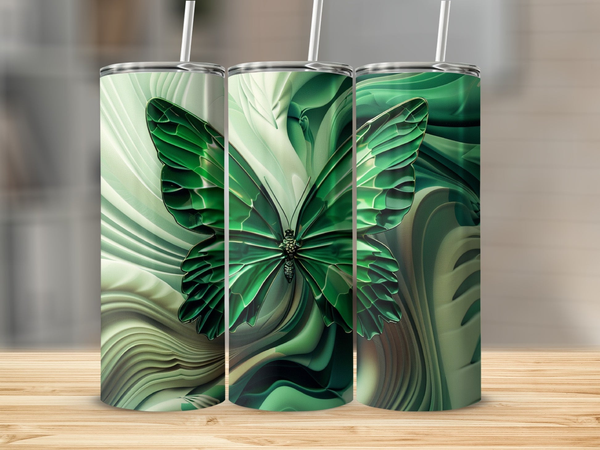 Three green tumblers with butterfly and abstract green swirl designs.