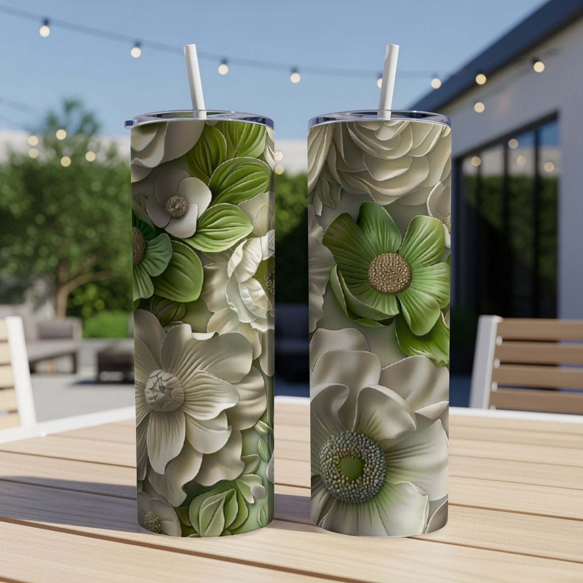 Two tall, cylindrical tumblers with a floral design featuring white and green flowers.