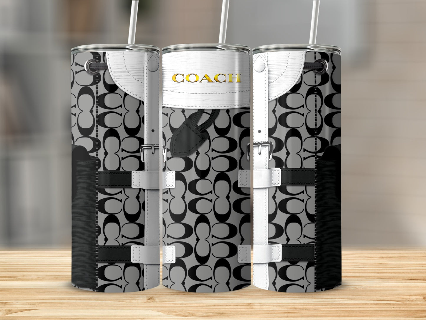 Coach logo tumbler with white buckle straps and straw.