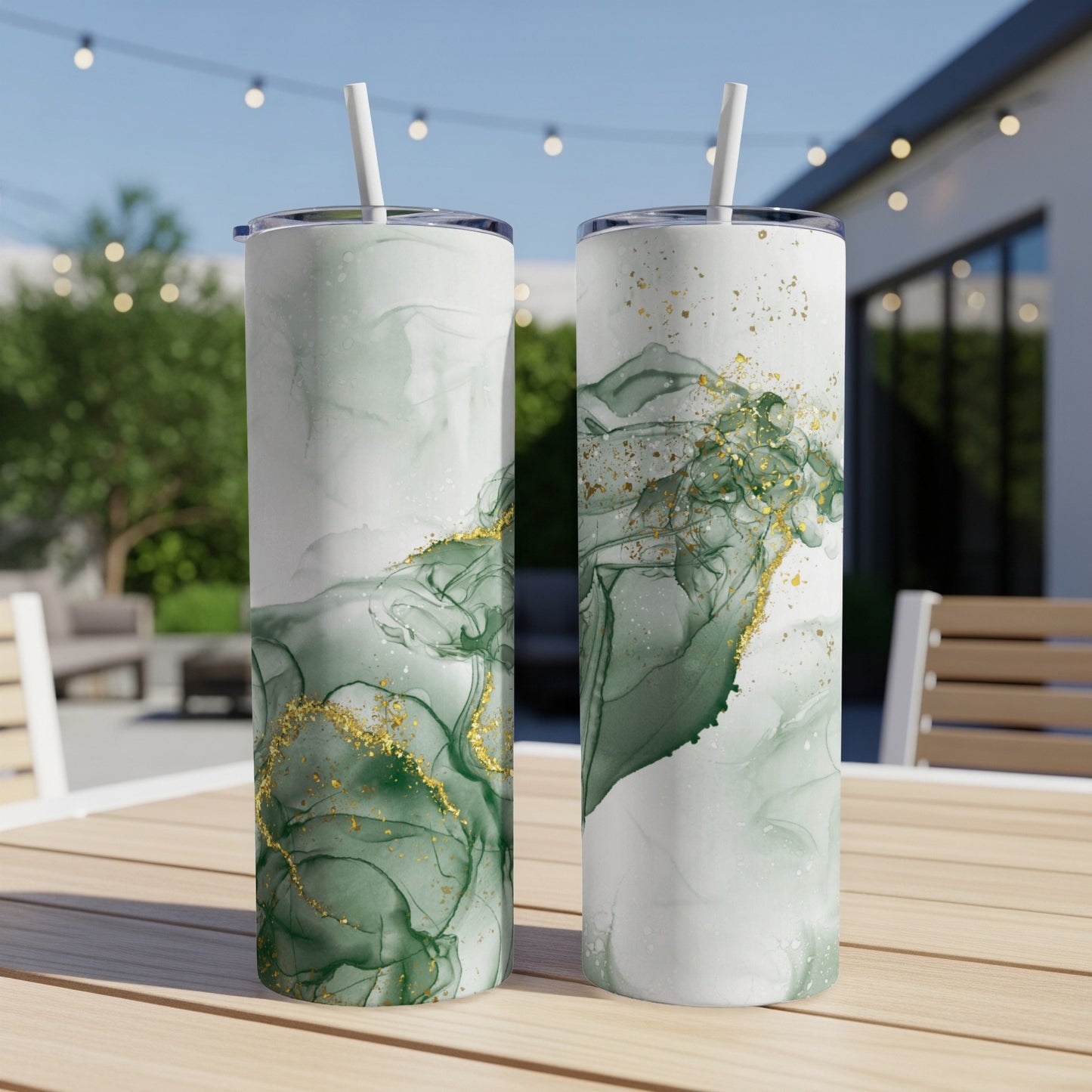 Two tall, slender tumblers with green and gold marbled design, on a wooden table.