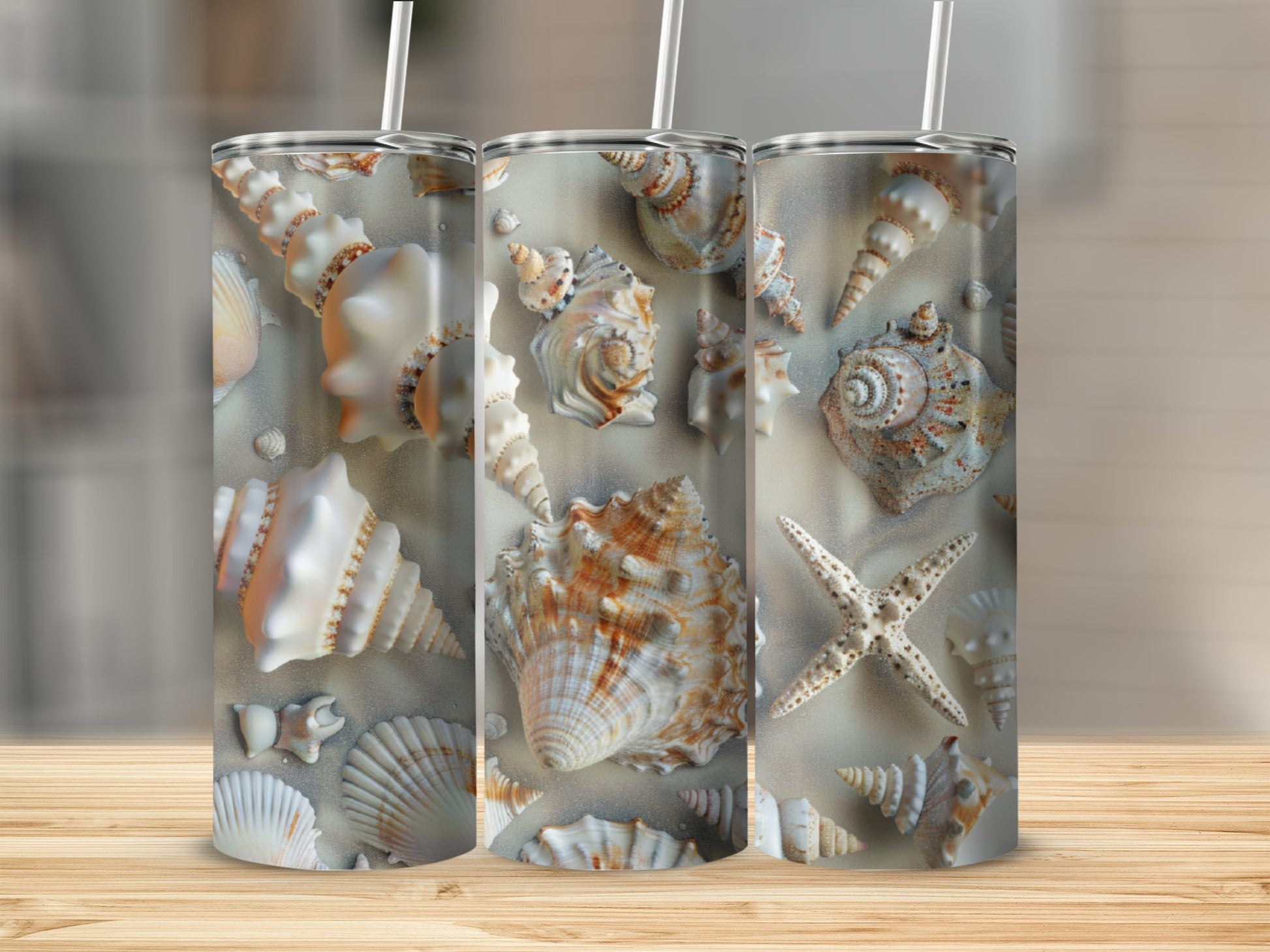 Three tumblers with a seashell and starfish pattern on a wooden surface.