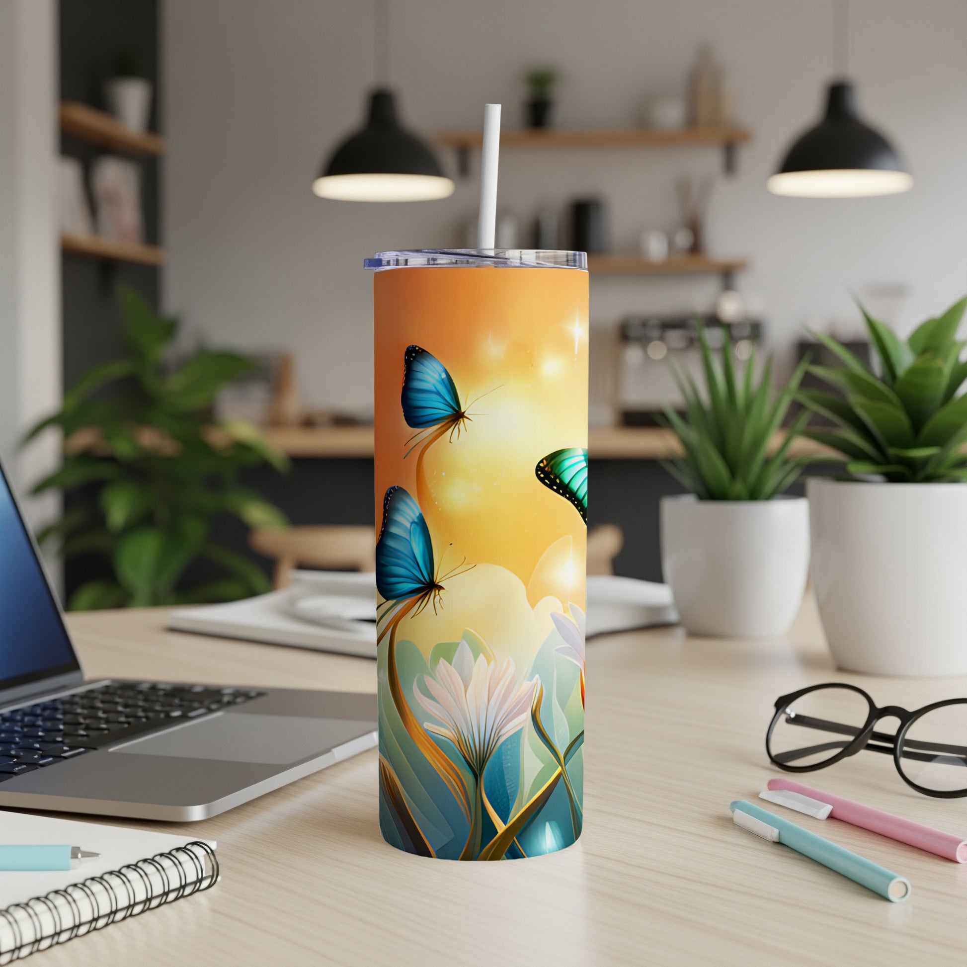 Orange tumbler with blue butterflies and floral design on desk.