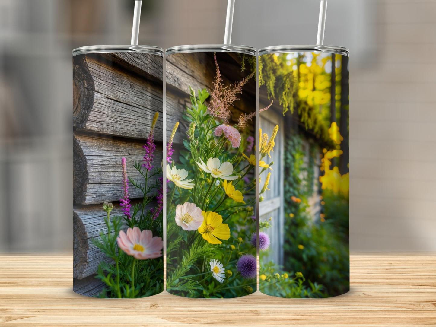 Three tumblers featuring colorful wildflowers and a rustic log cabin.