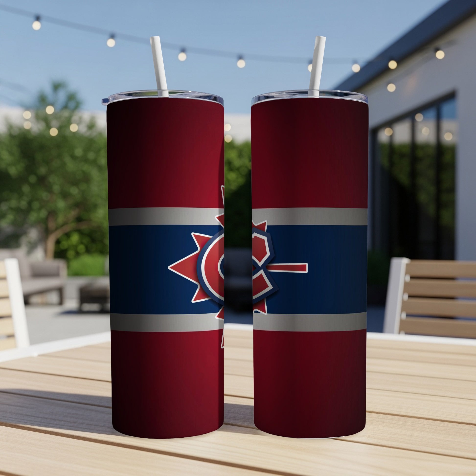 Two red tumblers with red, white, and blue logo under an outdoor patio setting.