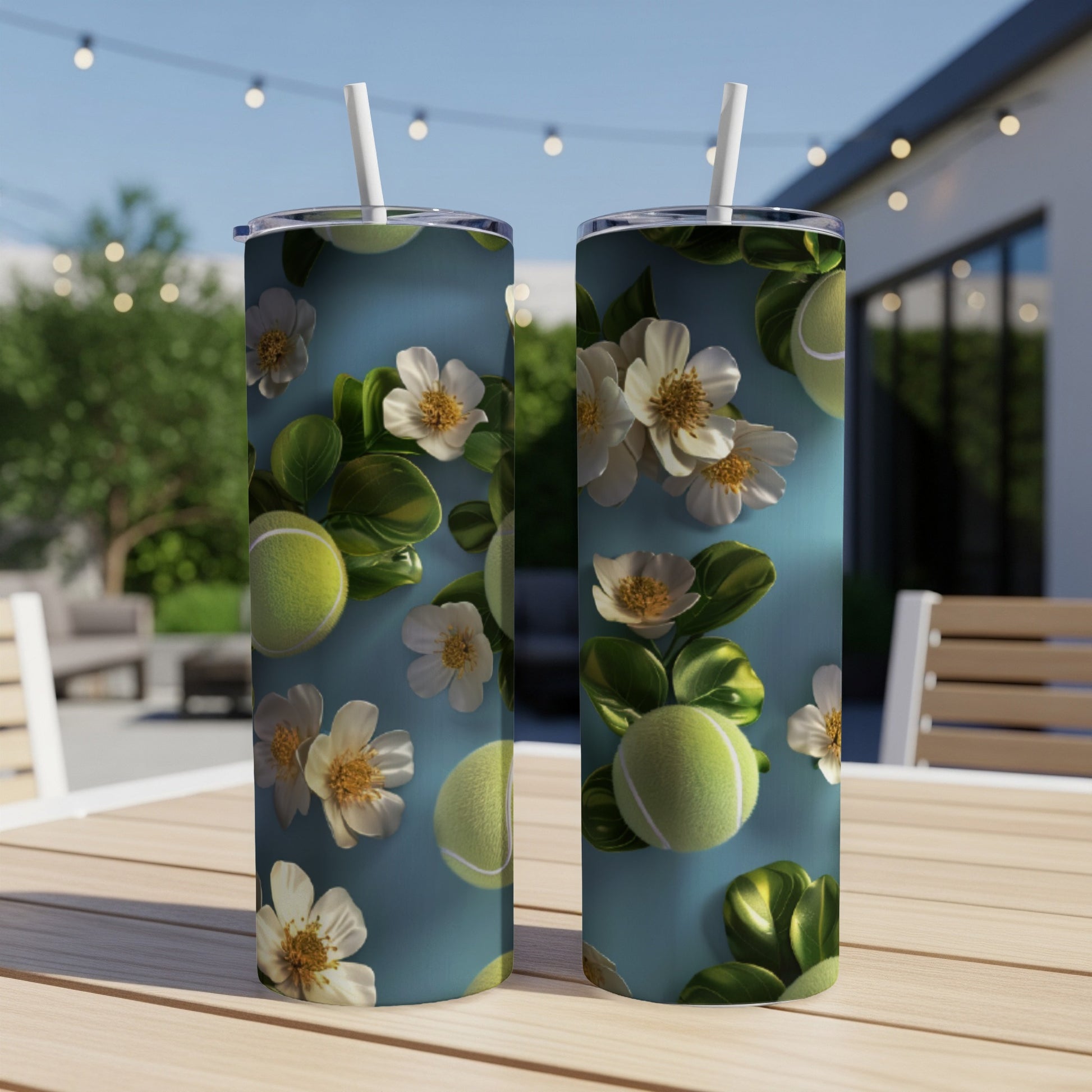 Two tall tumblers with tennis balls and white flowers on a wooden table.